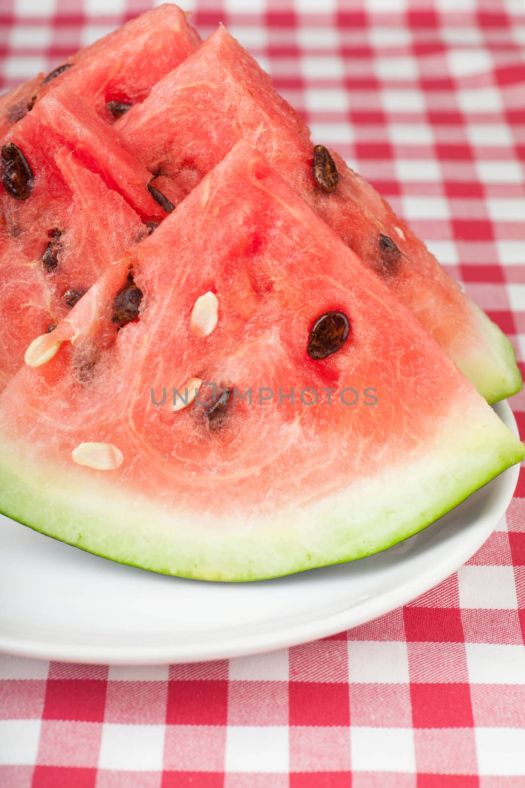 Fresh watermelon slices on a white plate