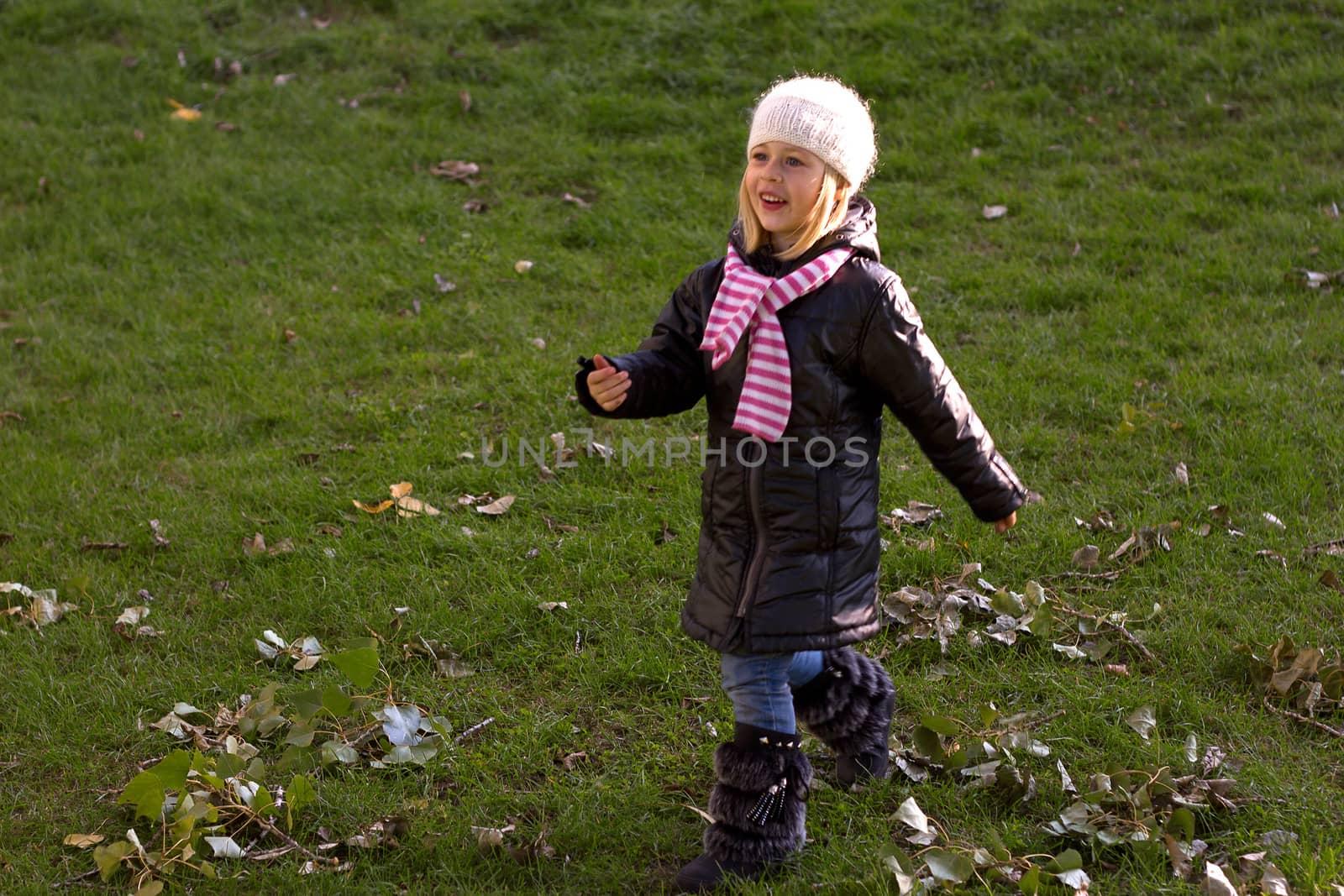 Adorable baby girl walking in an autumn field