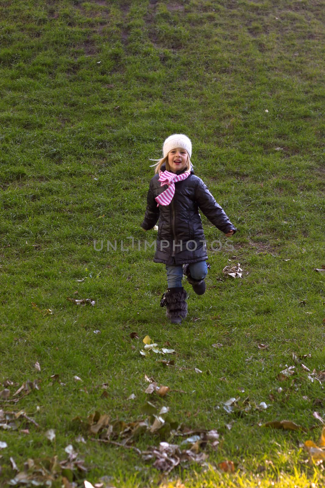 Adorable baby girl walking in an autumn field