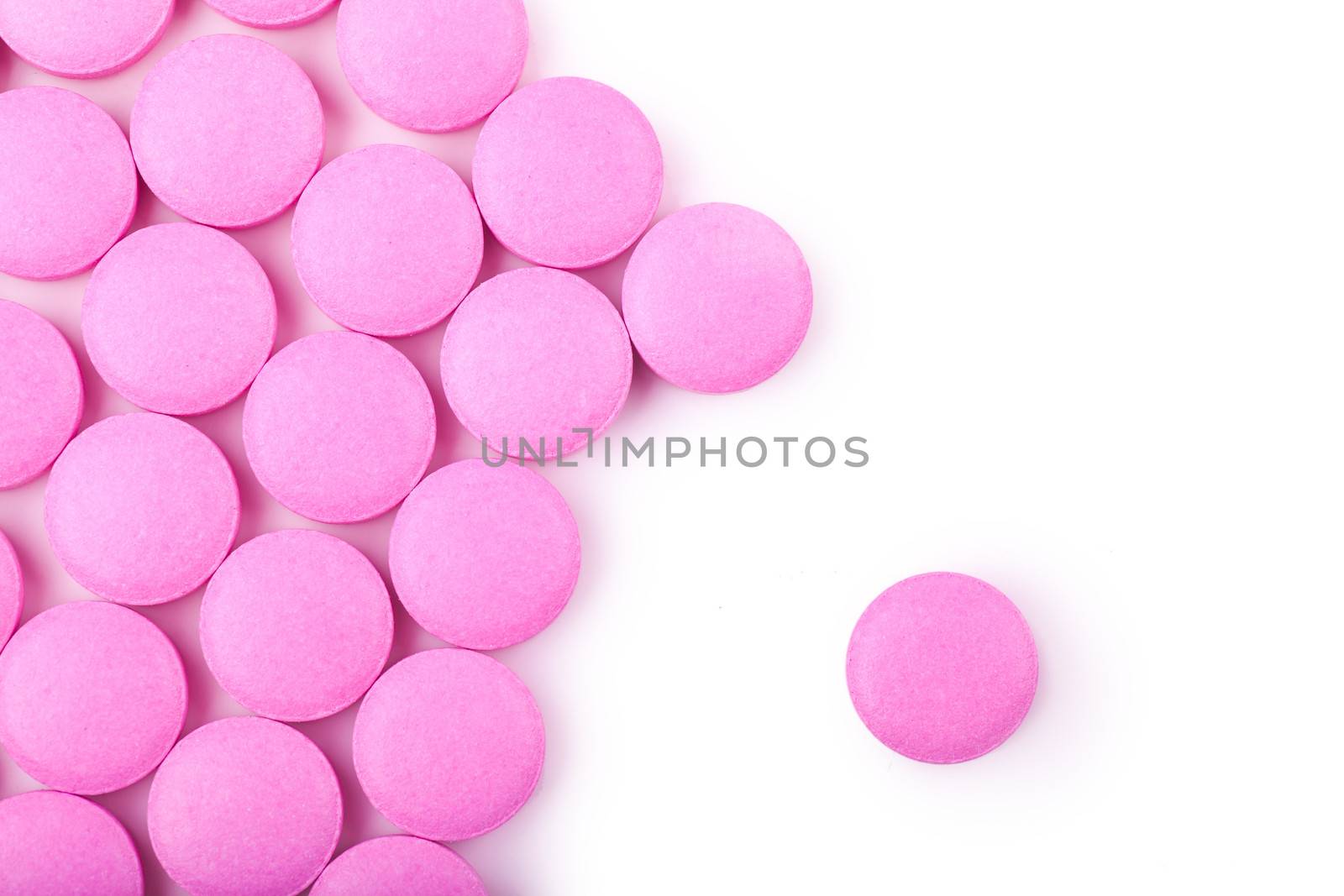 Macro view of pink pills over white background
