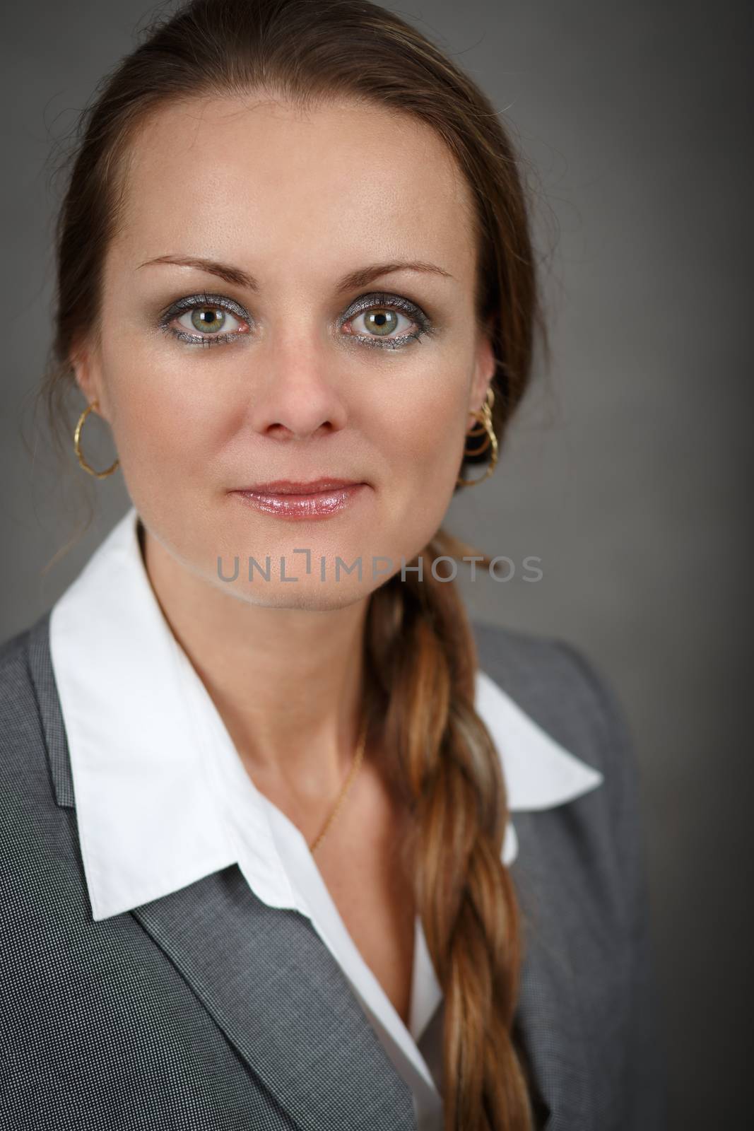 Portrait of middle age business woman on grey background with shallow focus