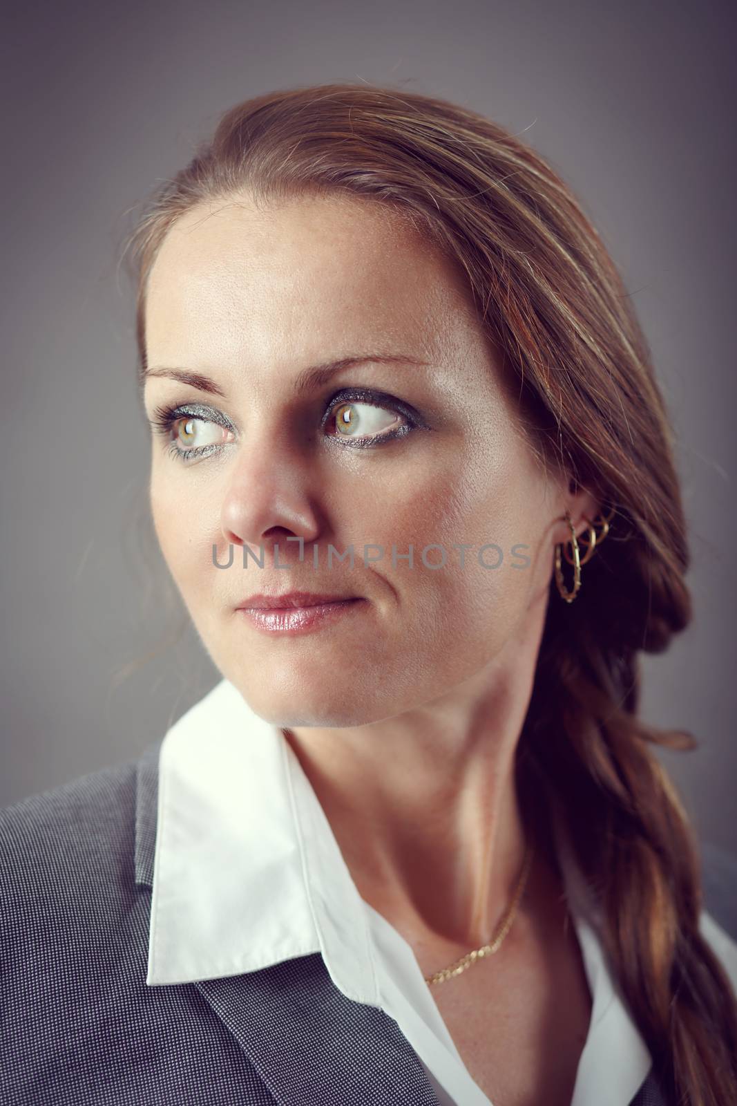 Portrait of middle age business woman on grey background with shallow focus