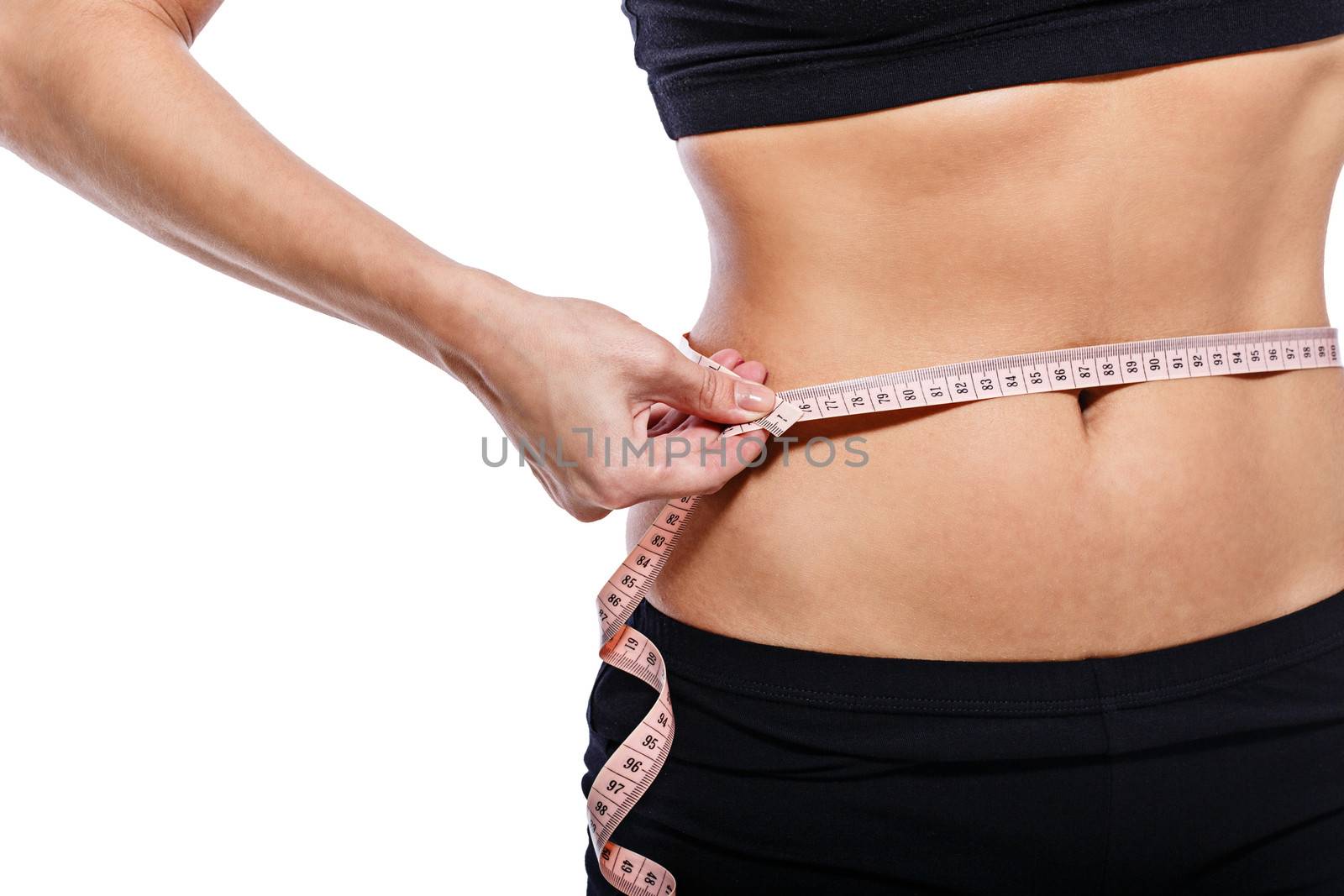 Girl measuring waist circumference after a grueling workout, isolated on white background