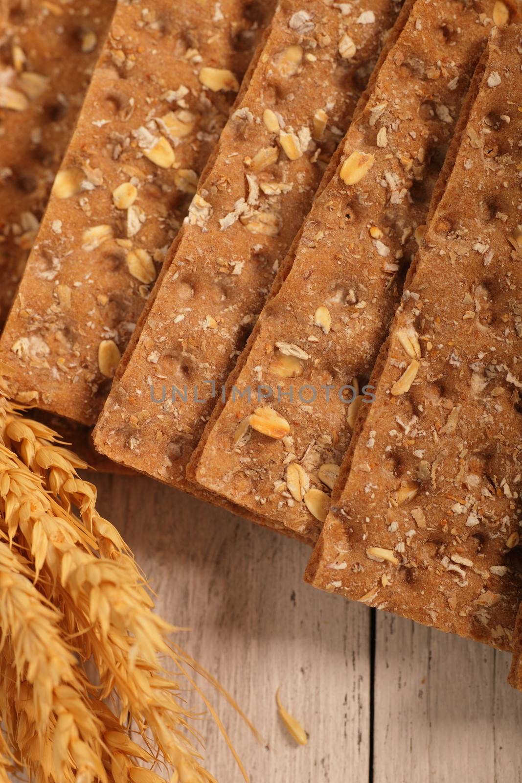 Overhead close up of the texture of wholegrain wheat crispbread crackers with ears of ripe wheat