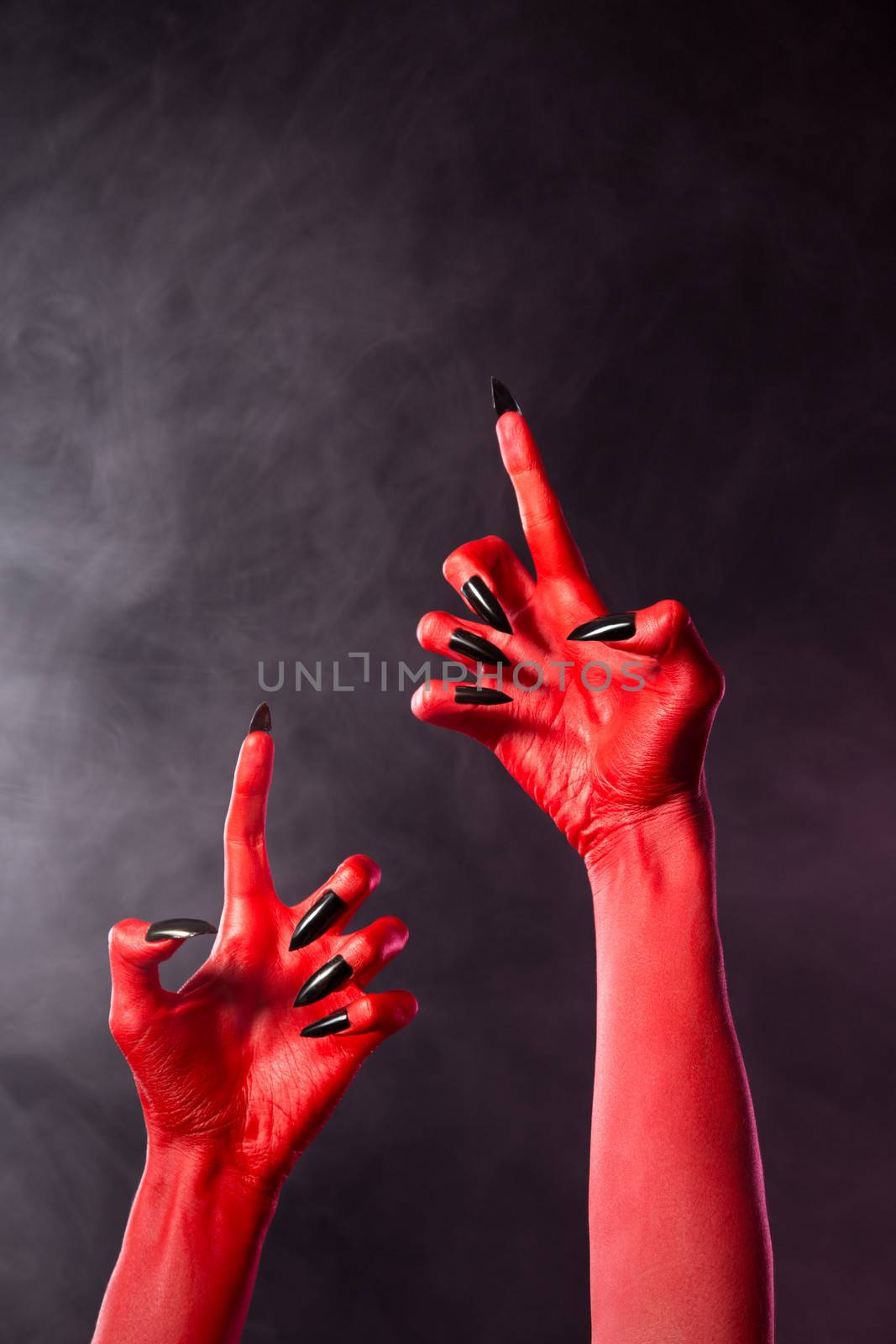 Creepy red devil hands with black nails, Halloween theme  
