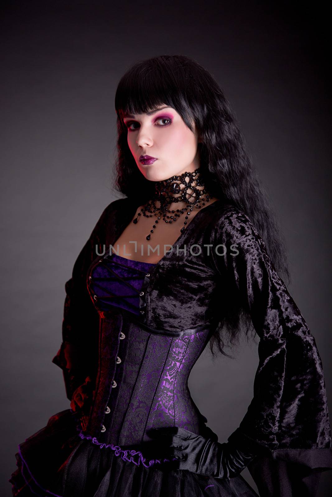 Portrait of attractive gothic girl in elegant medieval costume, studio shot on black background 