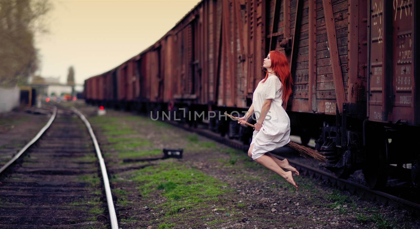 Redhead witch flying on the broom on train station 