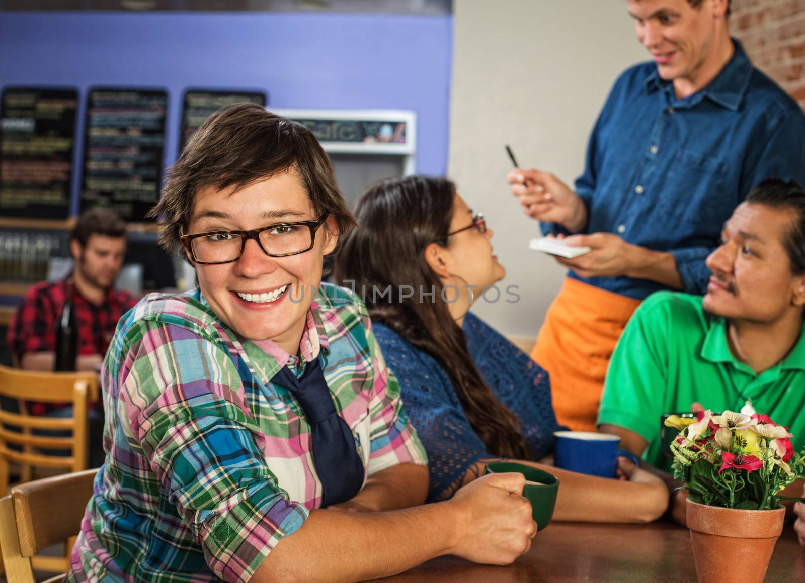 Cheerful young white female with friends in coffee house