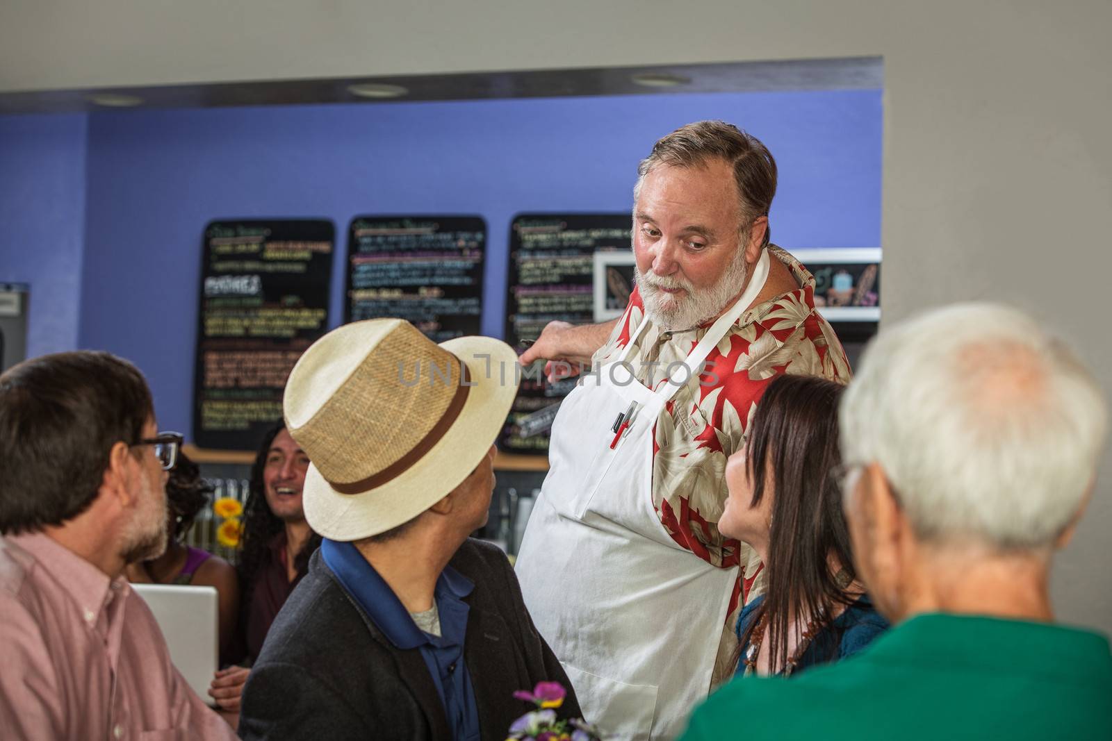Handsome cafe barista showing customers menu
