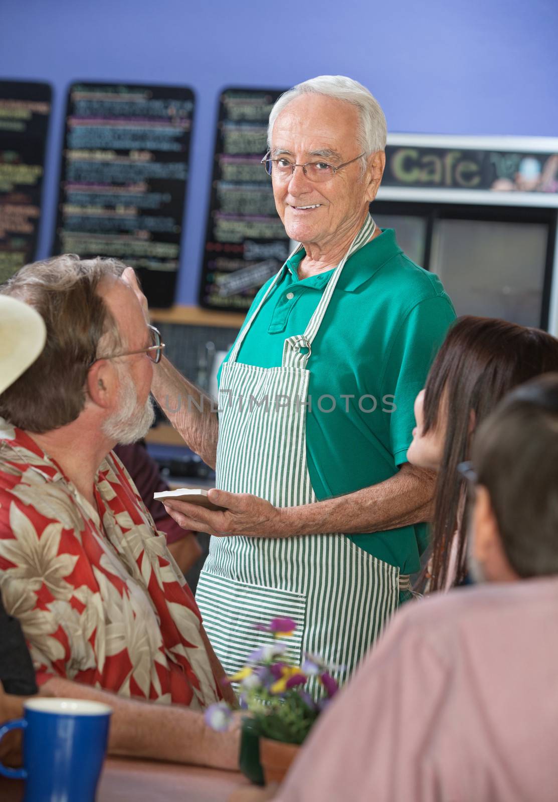 Smiling Cafe Worker with Customers by Creatista