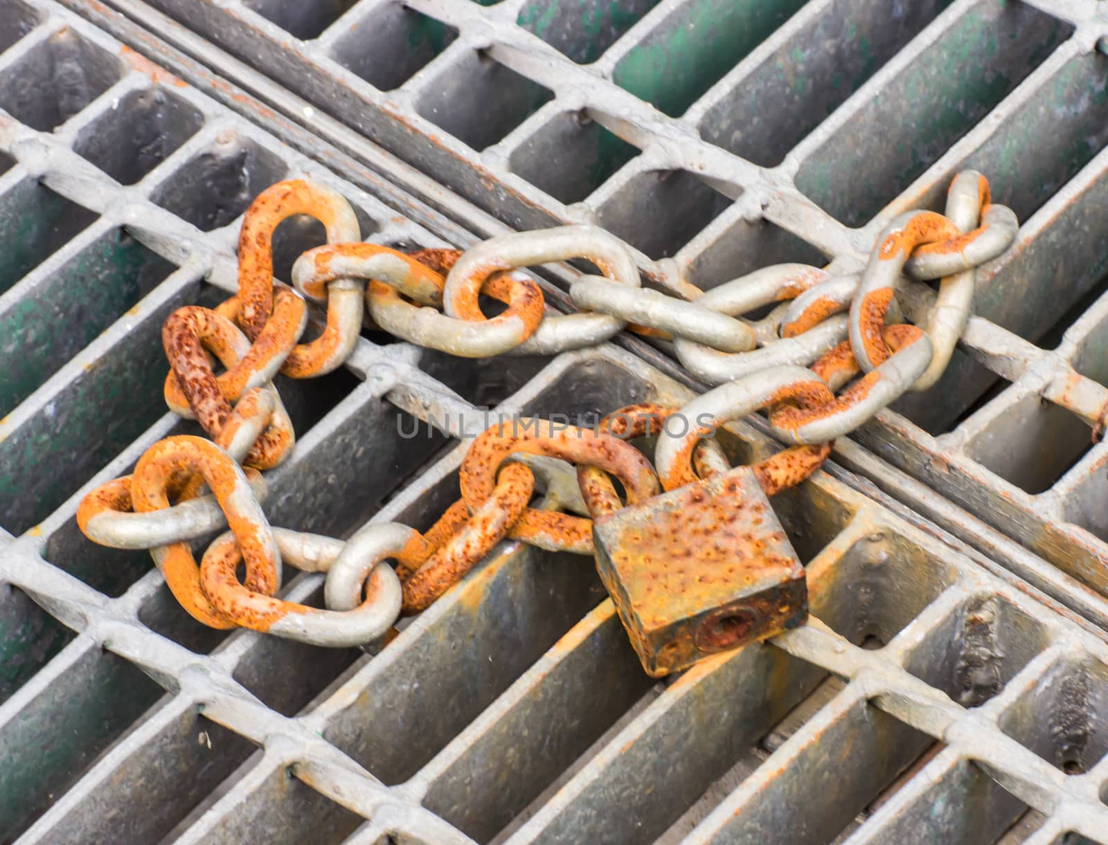Lock and chain on a steel ,Close up view of a large lock and chain on a steel have the rust.