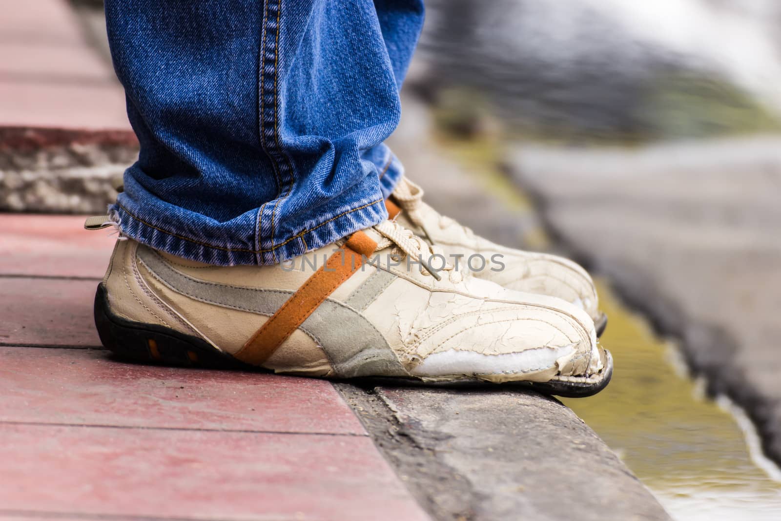 Ripped shoes, waiting someone at a bus stop in Bangkok, Thailand