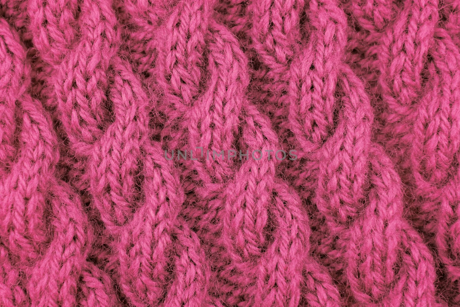 Closeup of pink coiled rope cable stitch knitting on the diagonal