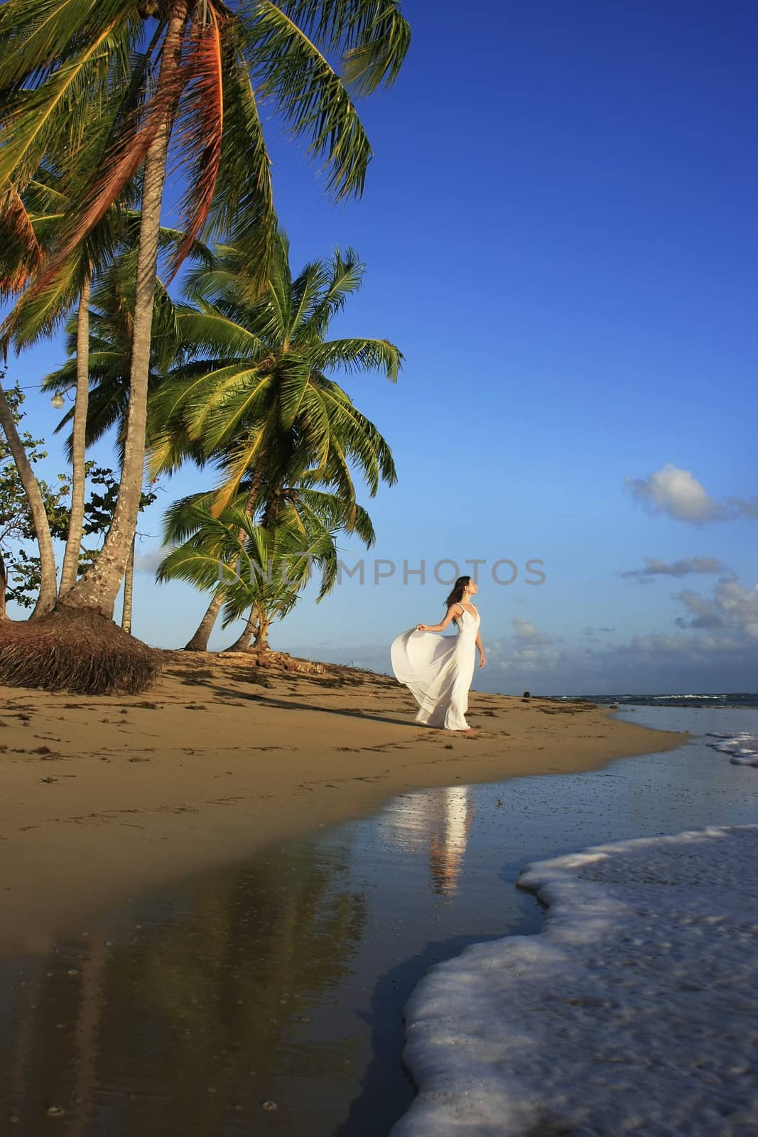 Young woman in white dress on a beach