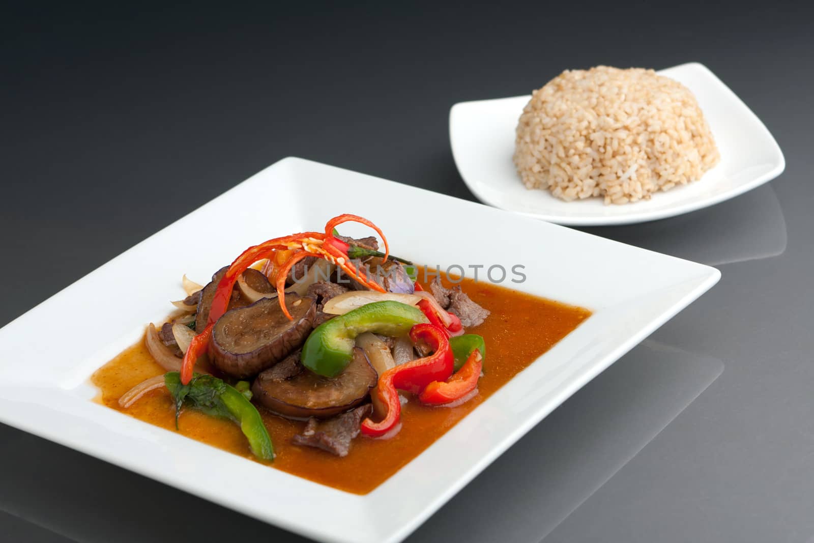 A beautifully presented dish of Thai food with mixed vegetables beef and brown rice.