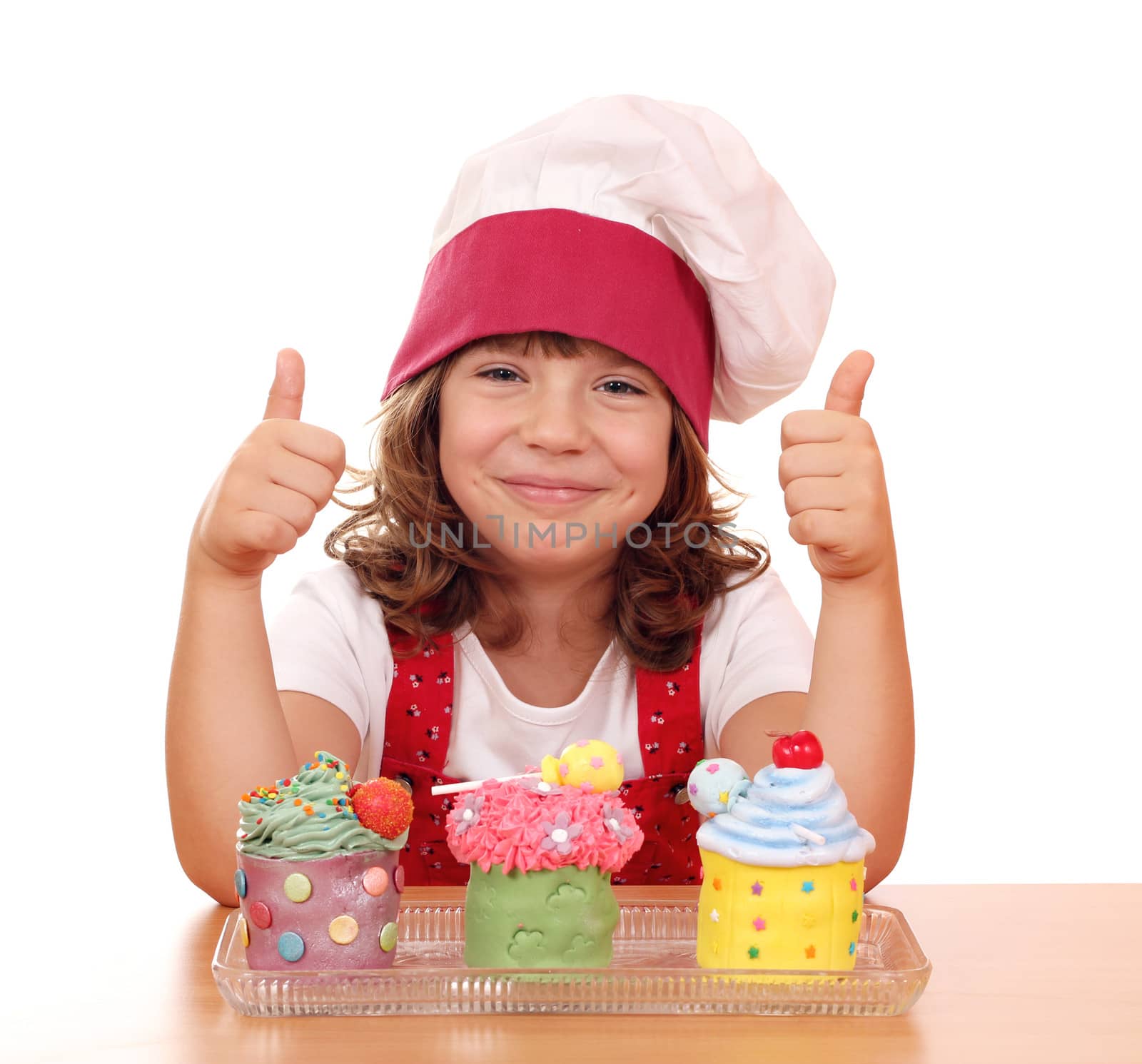 happy little girl cook with cupcakes and thumbs up