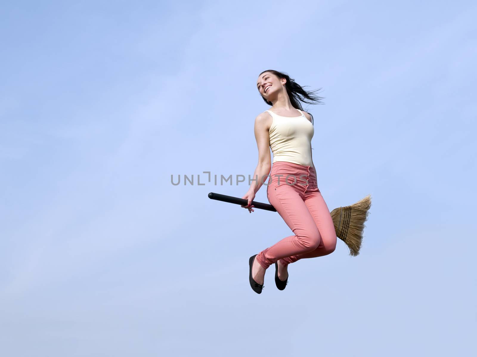 happy young woman flying with a broom