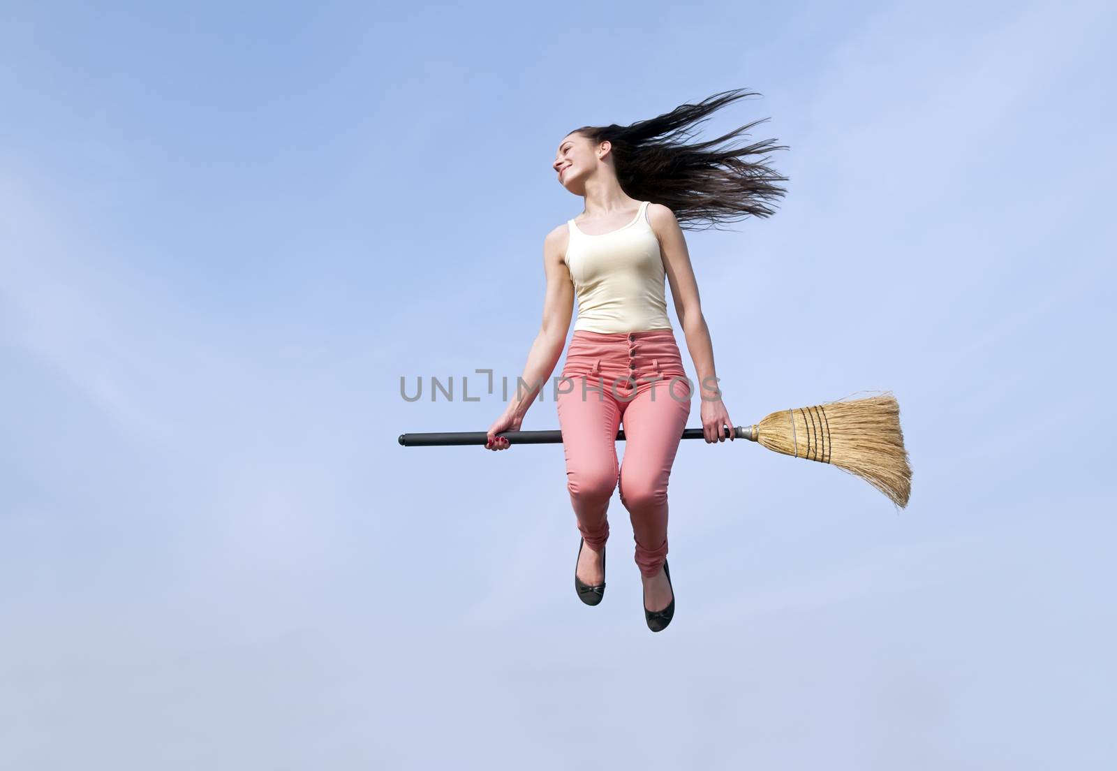  happy young woman flying with a broom