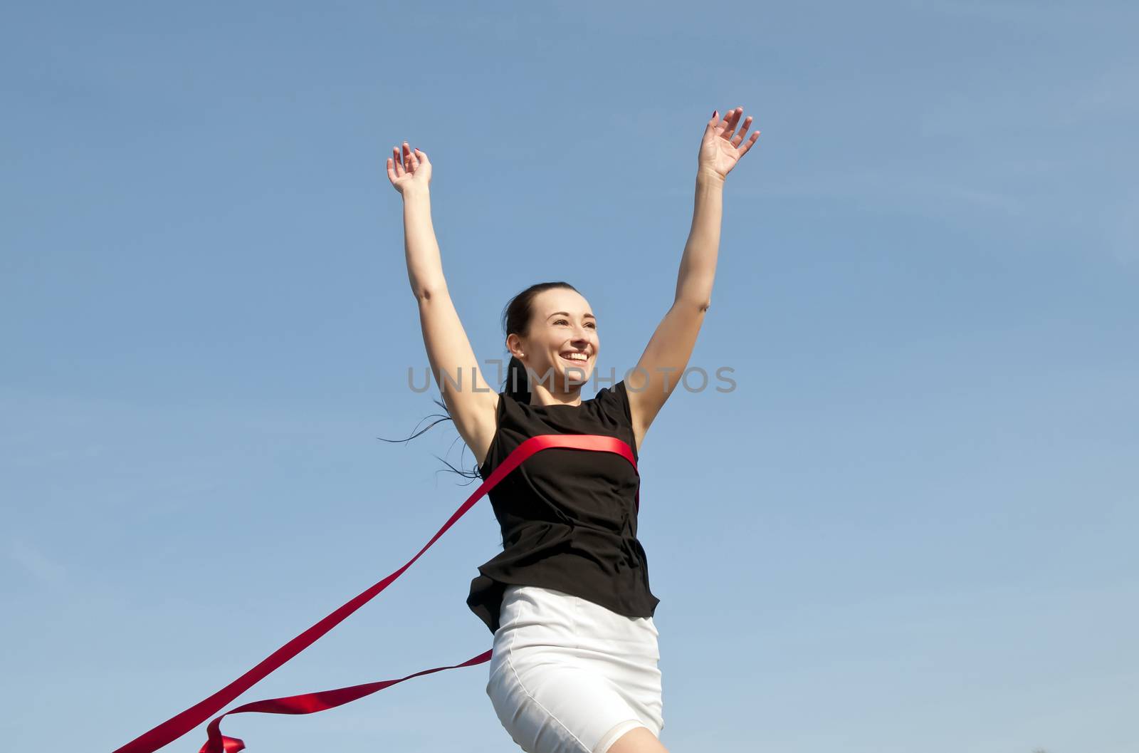 woman in skirt crossing finishing line