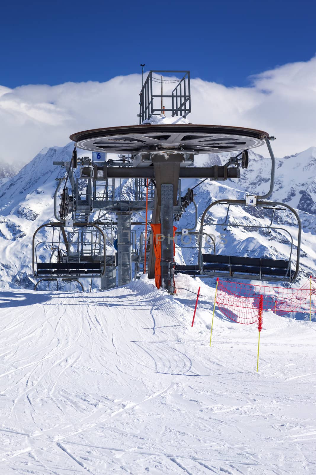 Vertical view of ski lift chairs on bright winter day 