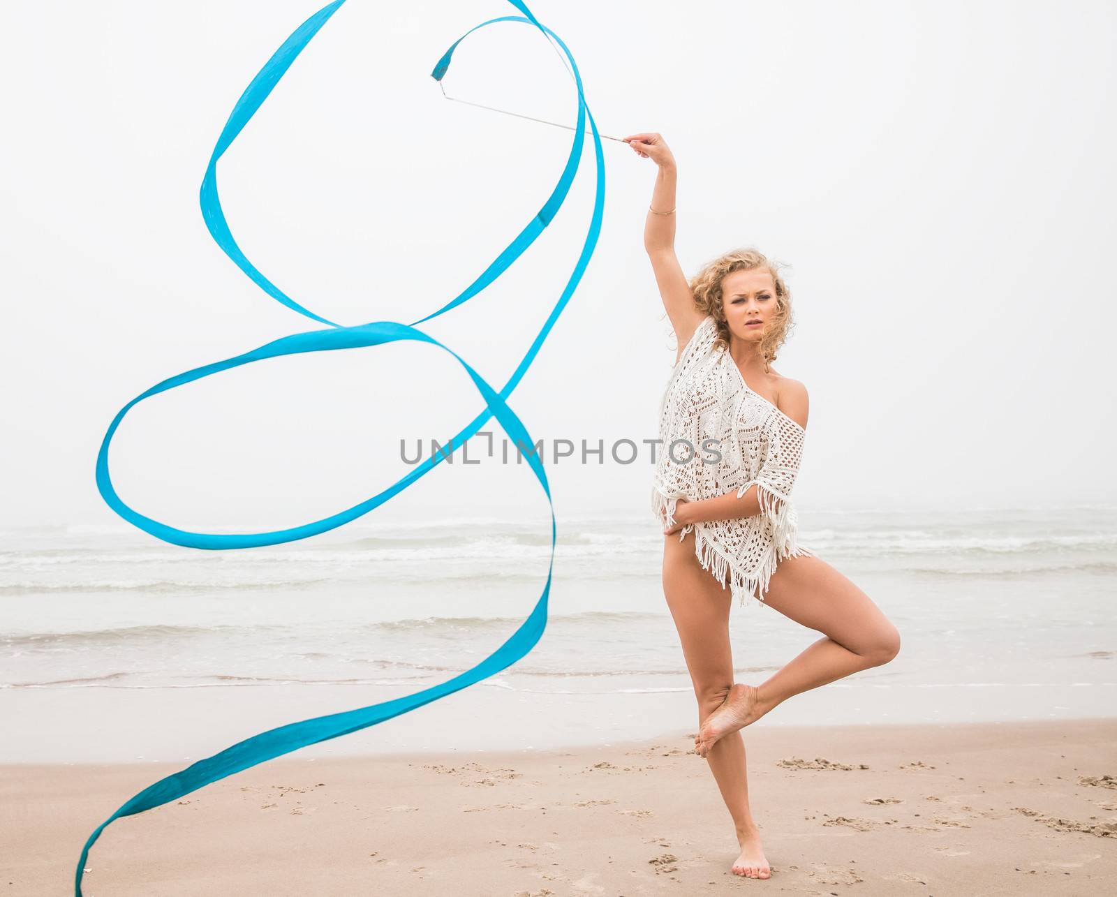 gymnast woman dance with ribbon on the beach by palinchak