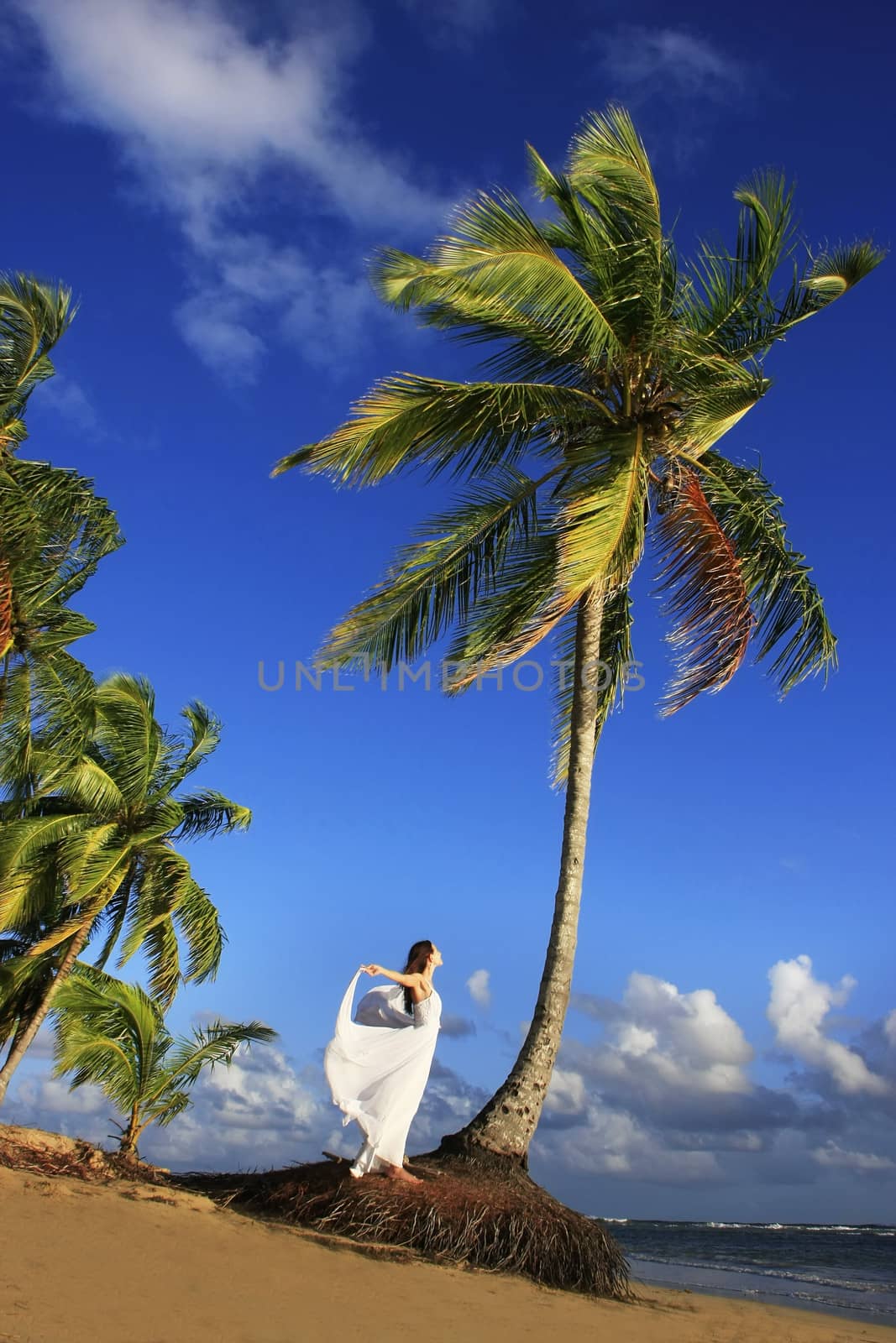 Young woman in white dress on a beach