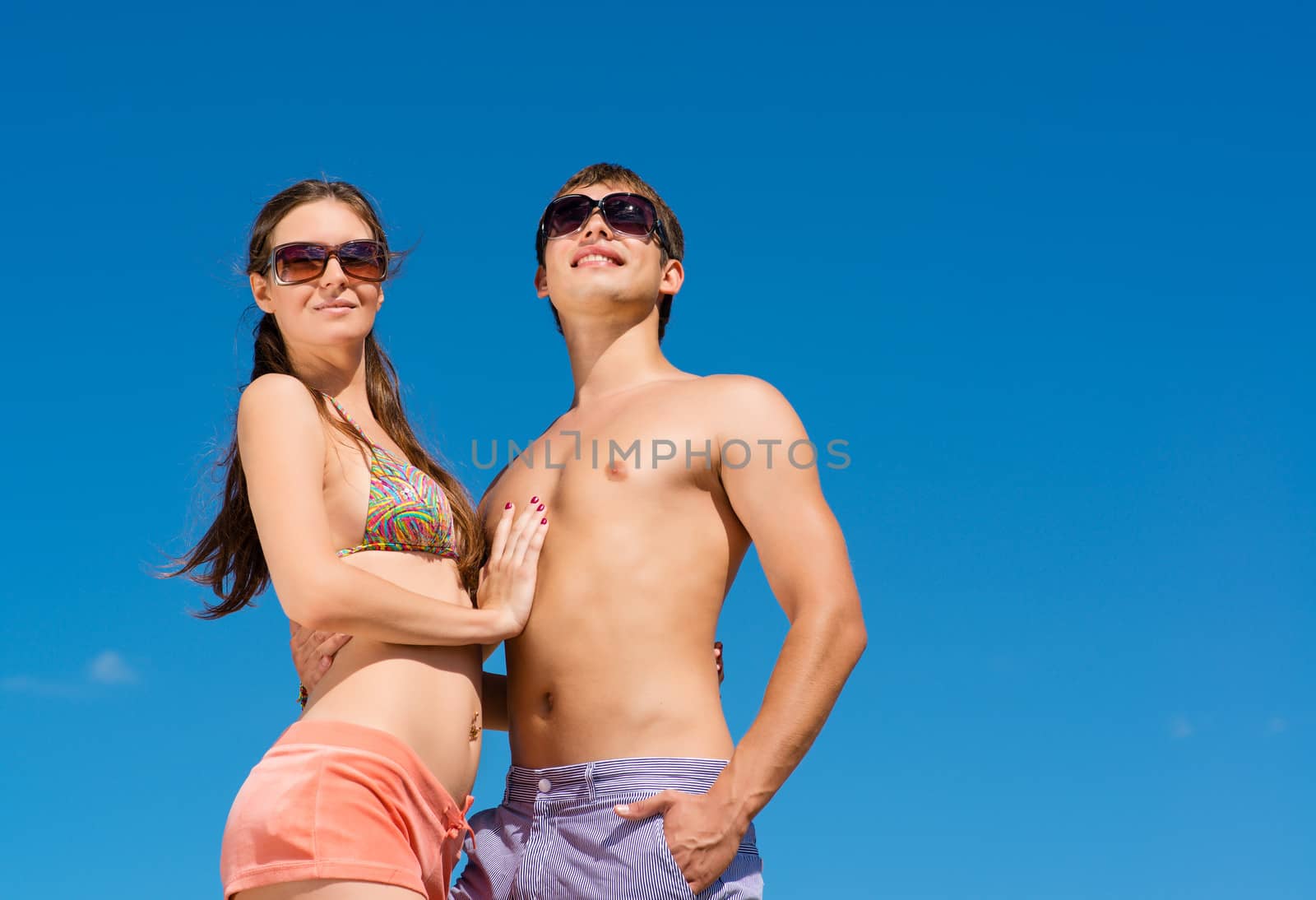 Young couple hugging on a background of blue sky, hold together honeymoon