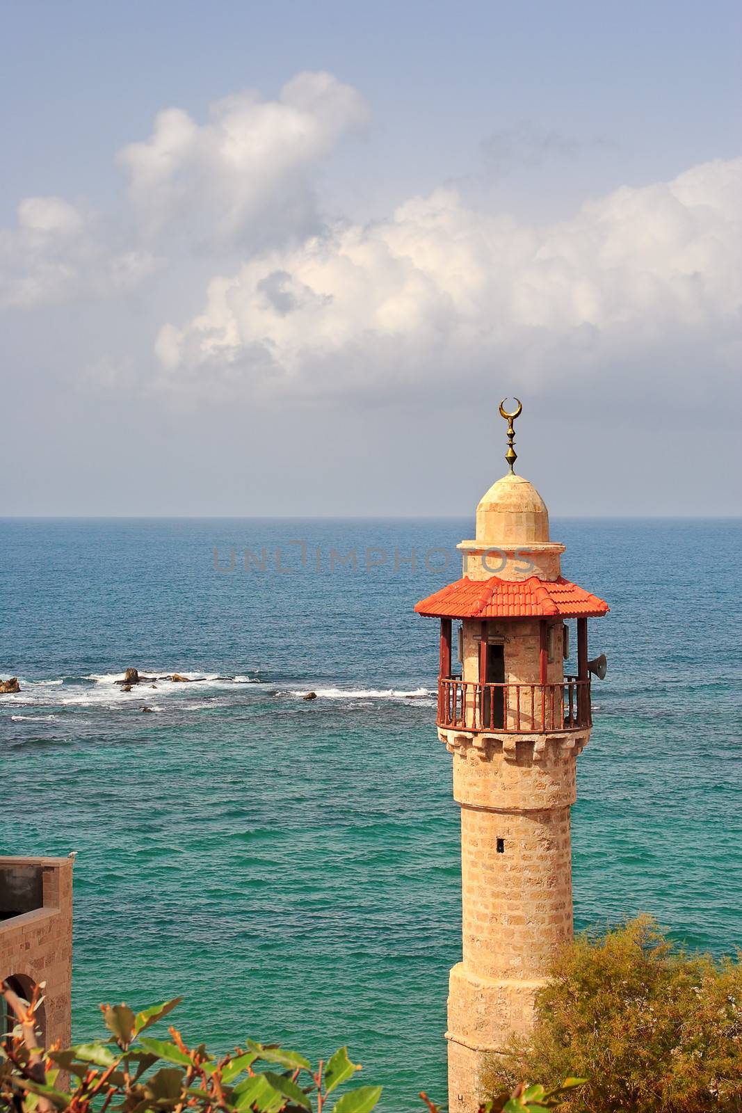 Vertical oriented image of old mosque's minaret and beautiful Mediterranean sea in Yafo in Israel.