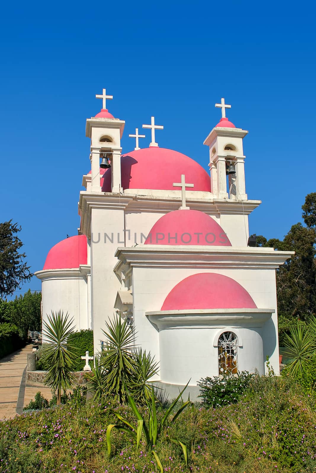 Vertical image of Greek Orthodox Church of the Seven Apostles under clear blue sky in Capernaum, Israel.