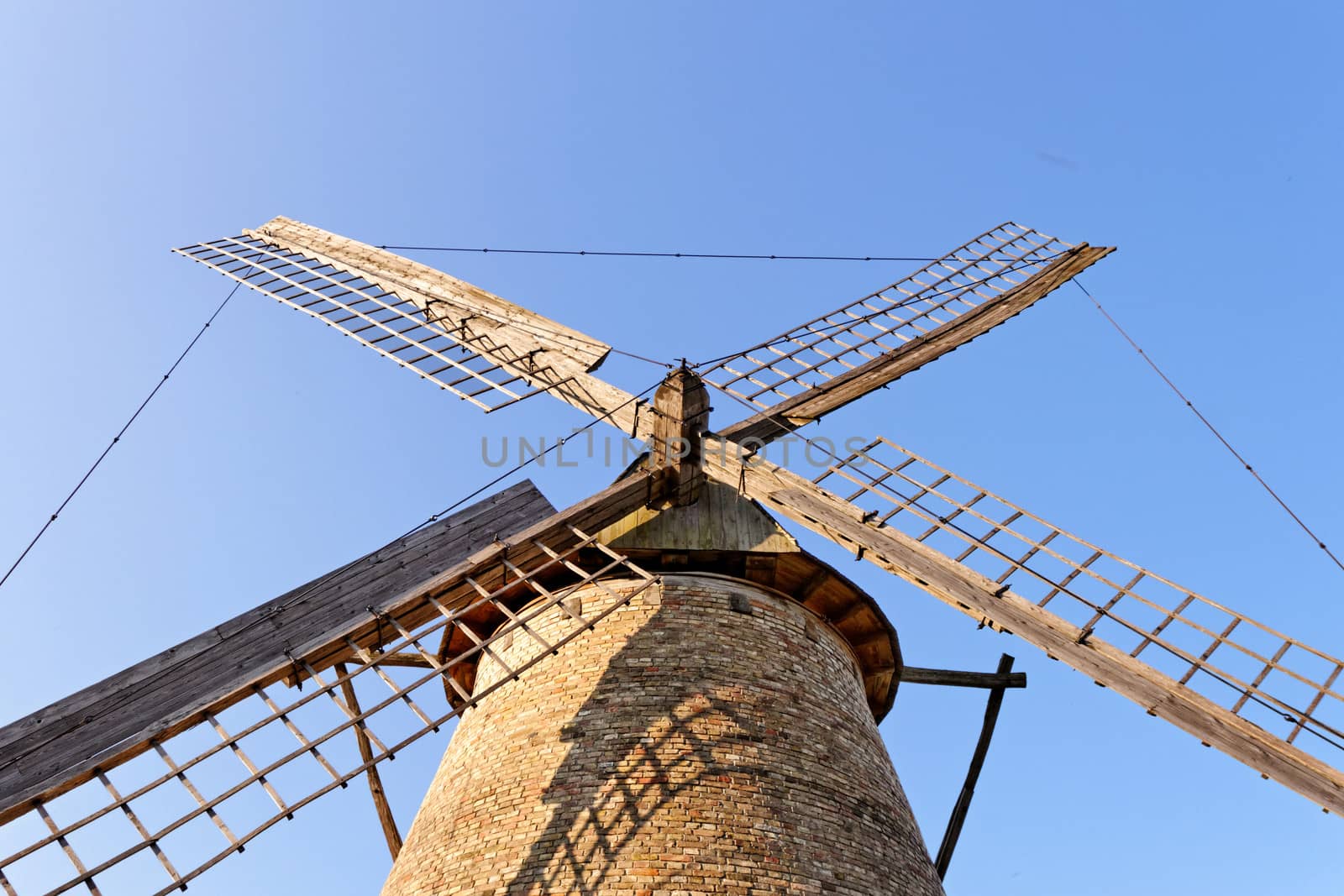 Old wooden windmill against the blue sky