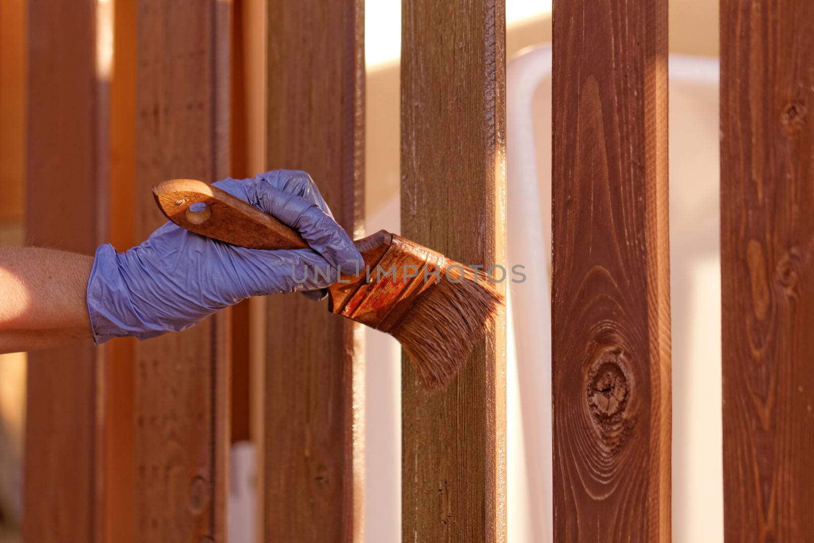 planks fence dyeing with brown paint and brush