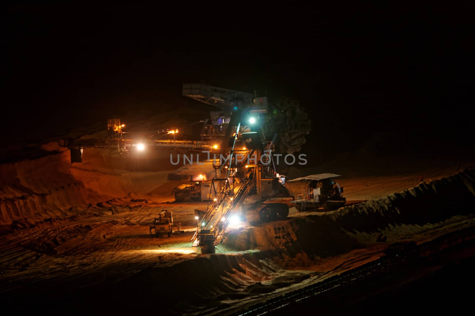 Coal mining in an open pit with huge industrial machine at night shoot