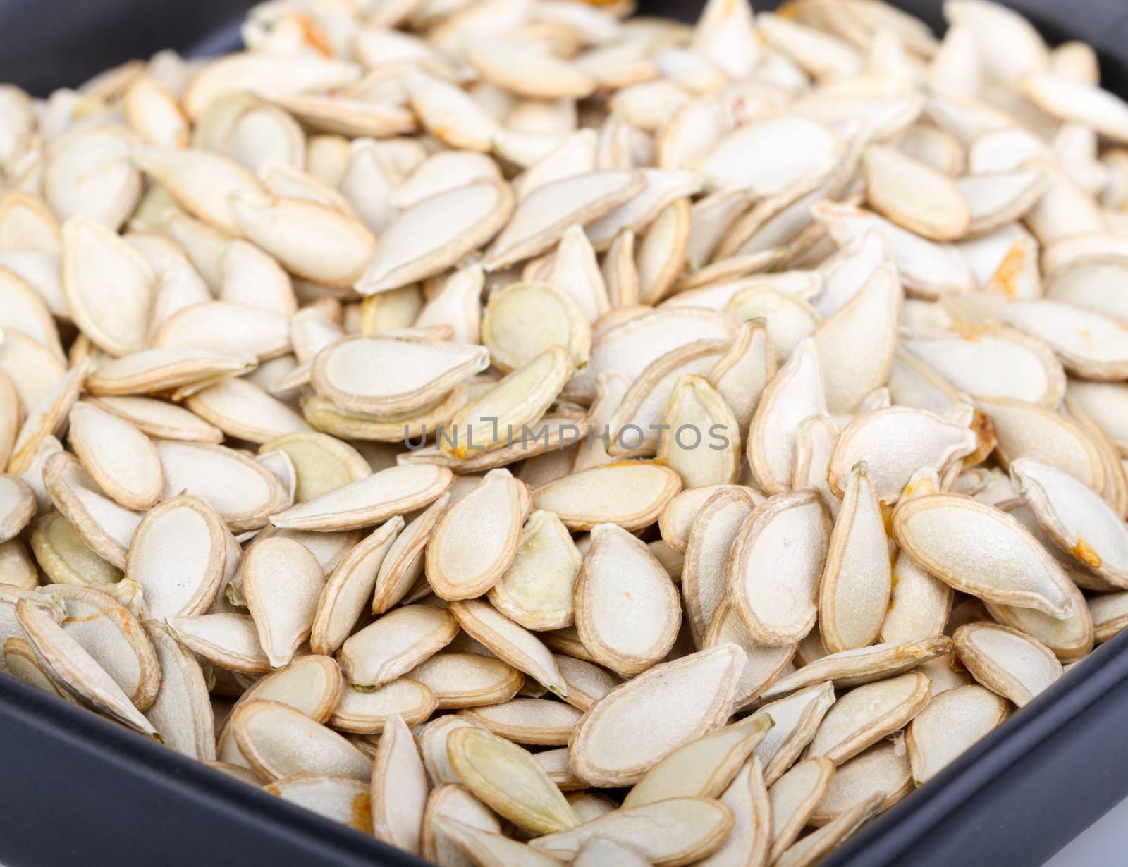 Pumkin seeds on black dish - close up