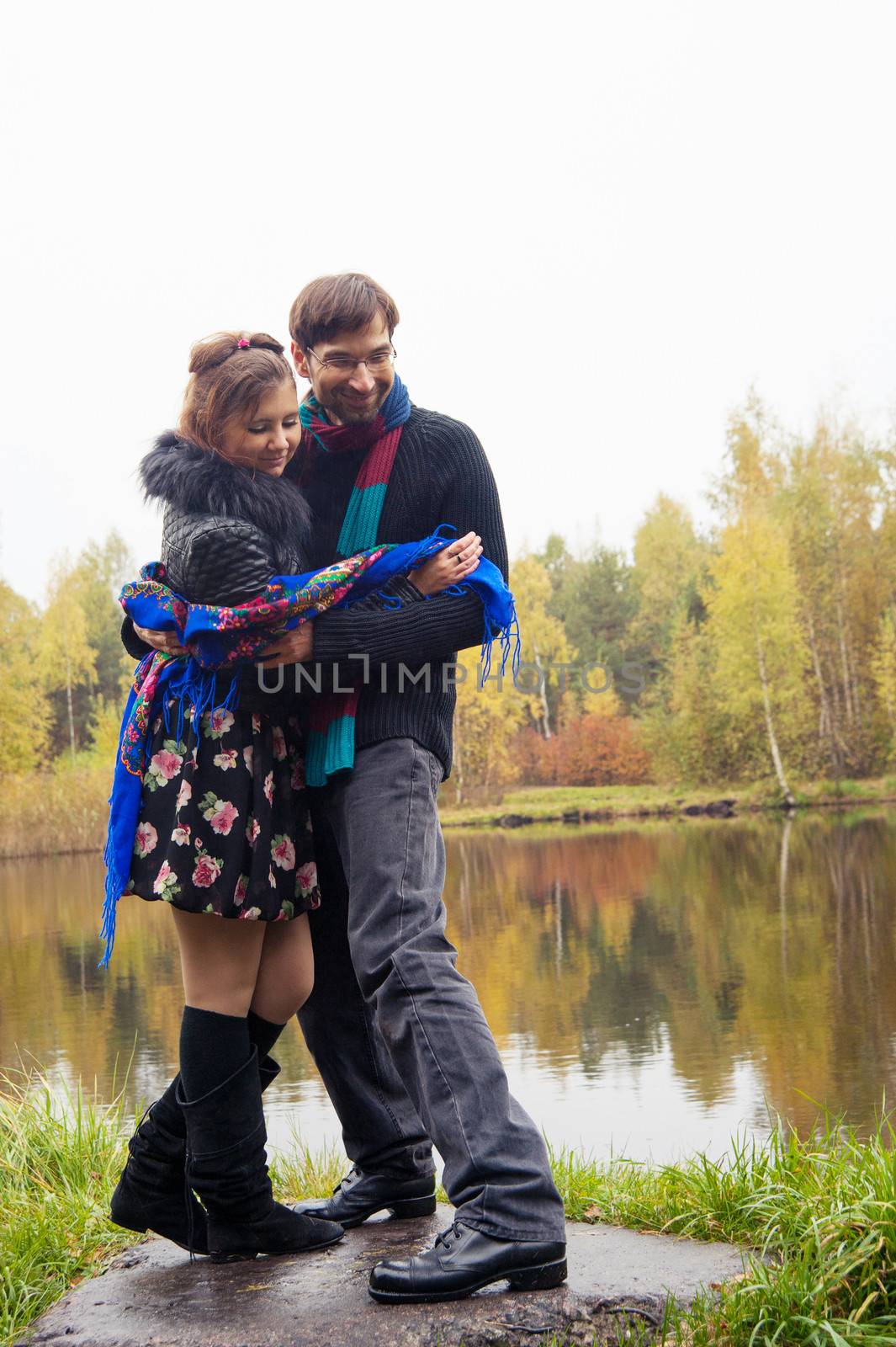 Beautiful loving couple dancing at a lake in autumn