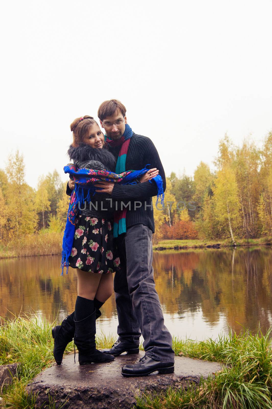 Beautiful loving couple dancing at a lake in autumn