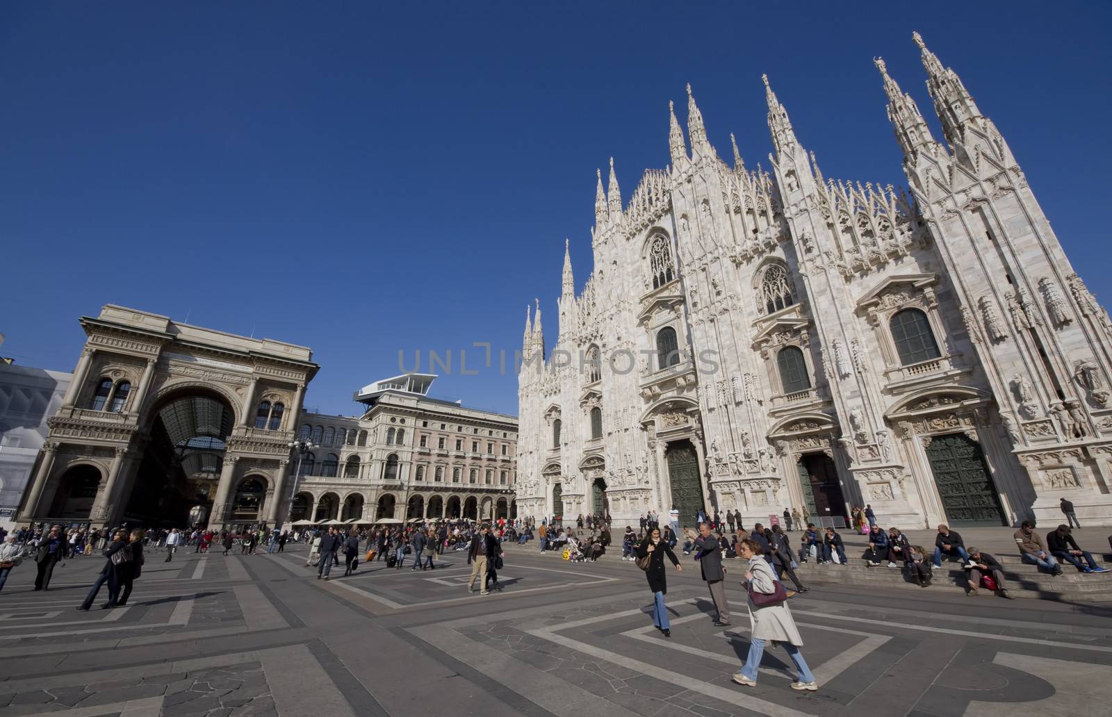 Milan, Italy - March 2013: Tourists at Piazza Duomo in Milan, famous city of Italy. From 2006, Milan was the 42nd most visited city worldwide, with 1.9 million annual international visitors.
