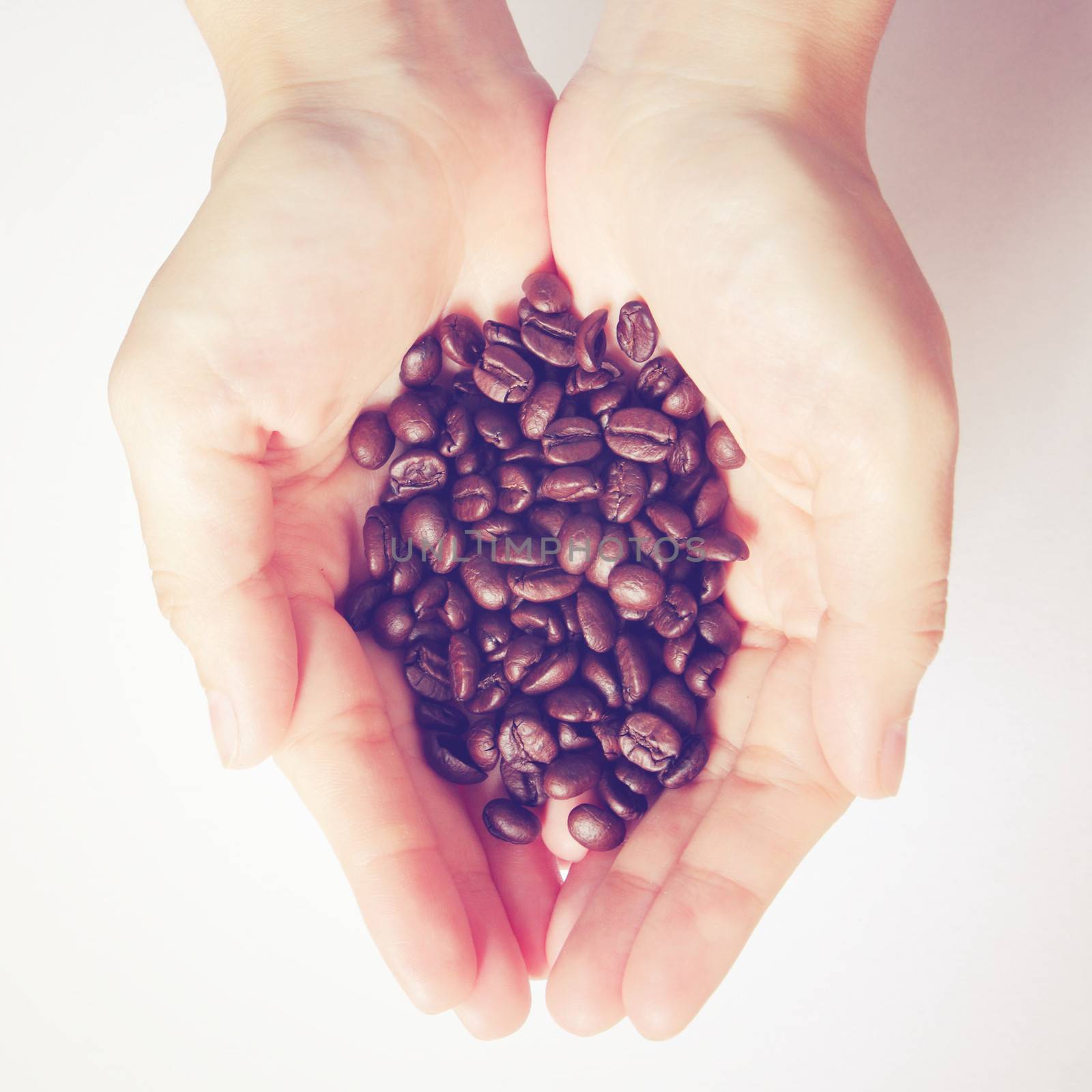 Coffee beans in hands with retro filter effect 