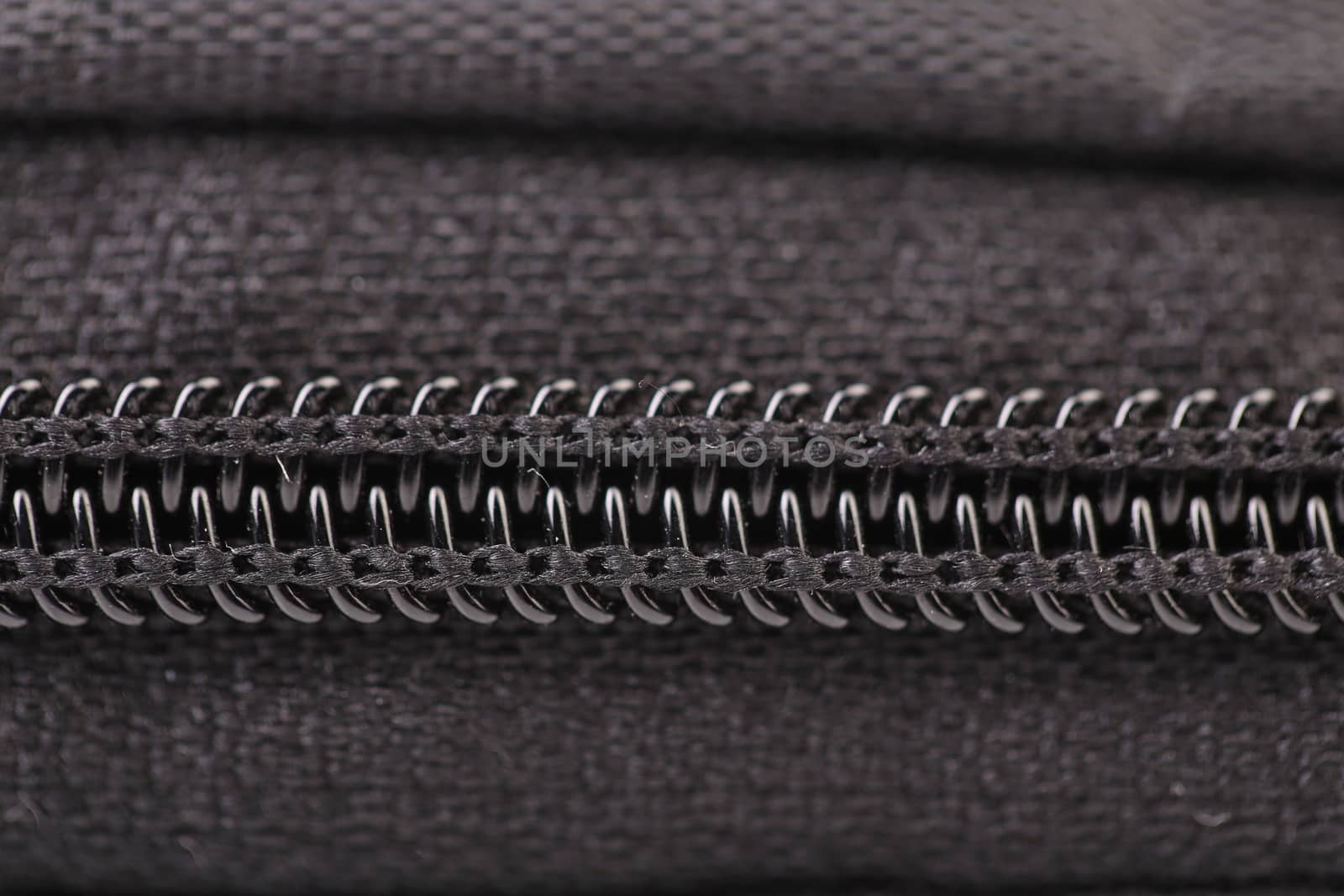 Plastic black zipper of case. Macro. Whole background.