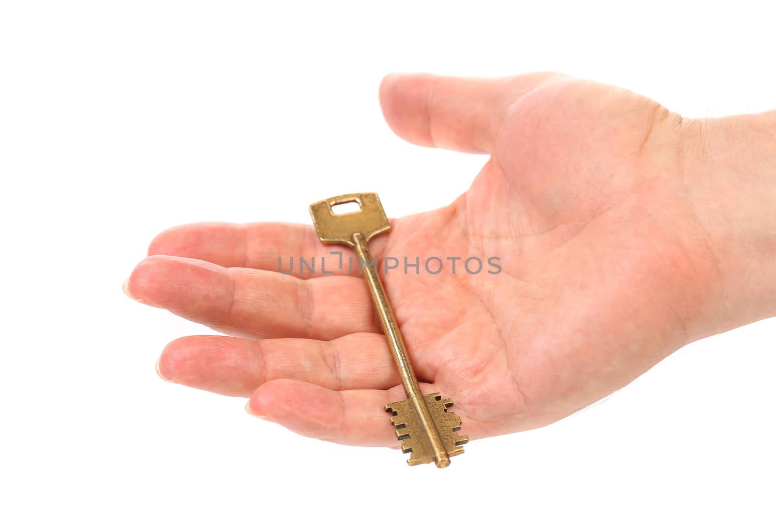 Hand holds bronze steel key. White background.