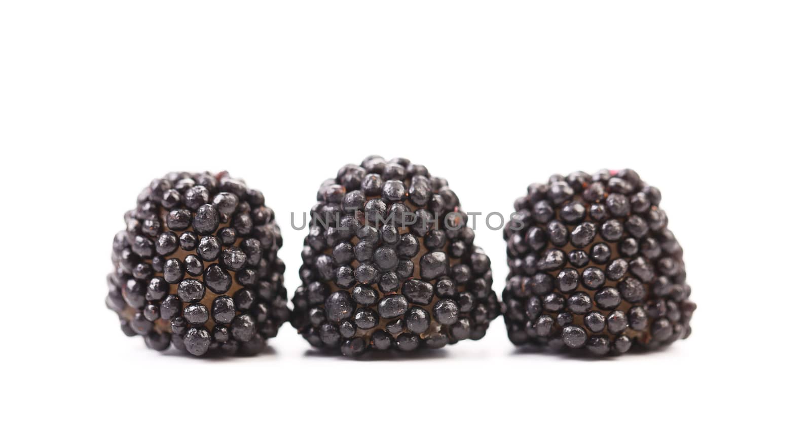 Three black jujube colored balls on a white background