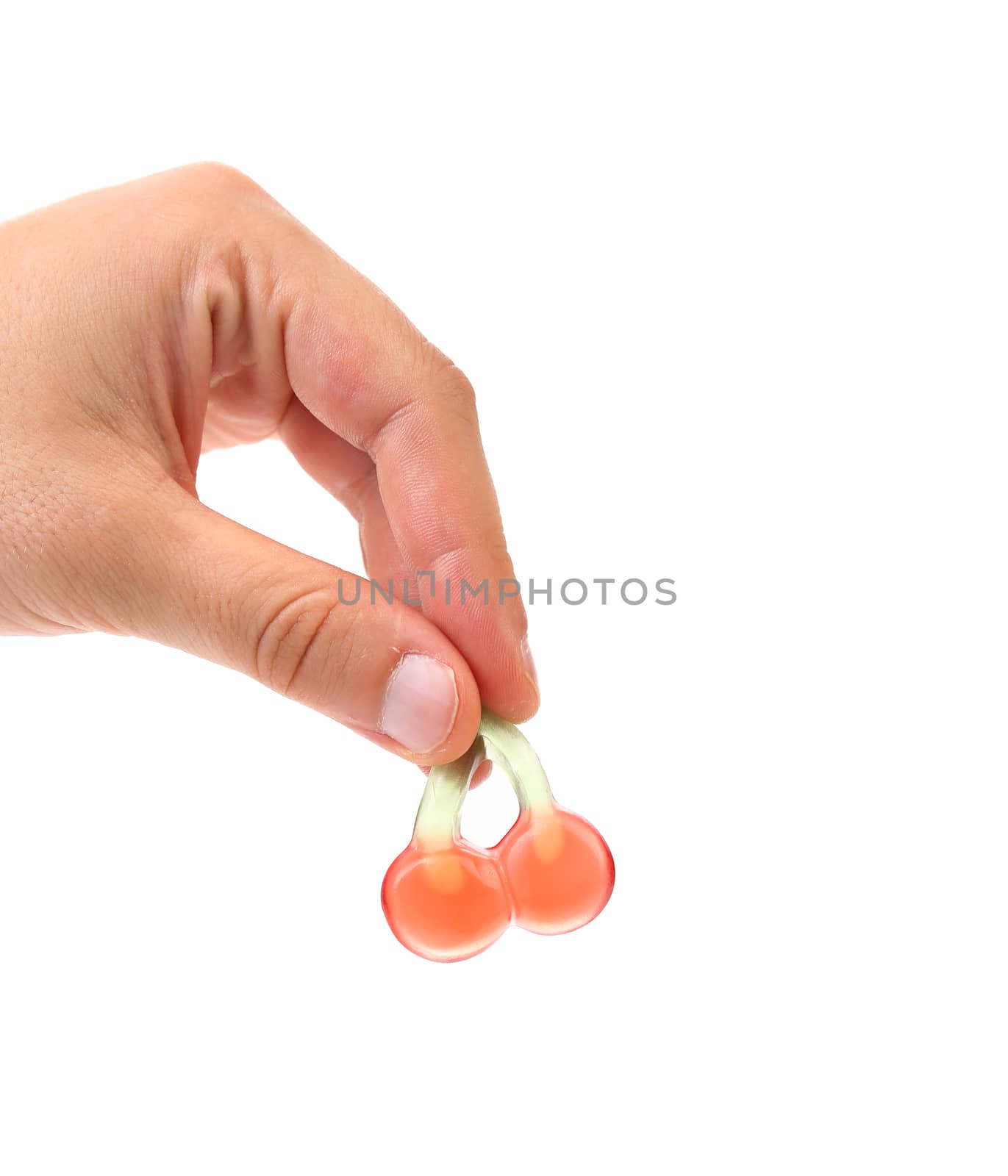 Hand holds fruit jelly in form of cherries. White background.