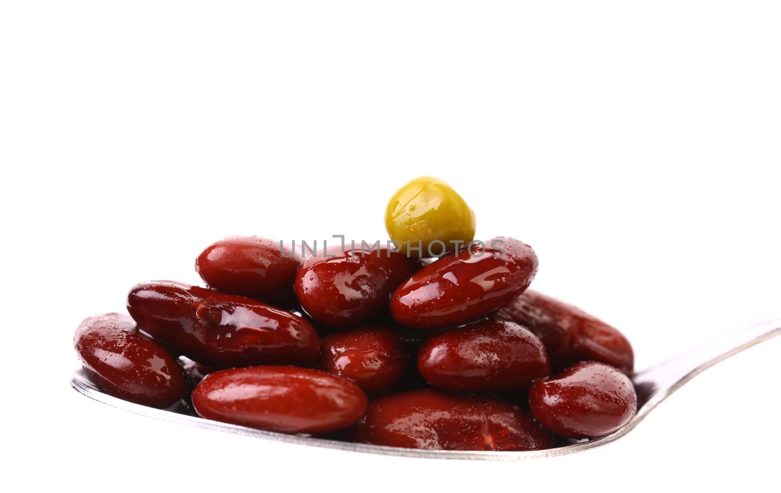 Preserve beans and pea on a spoon. White bacground.