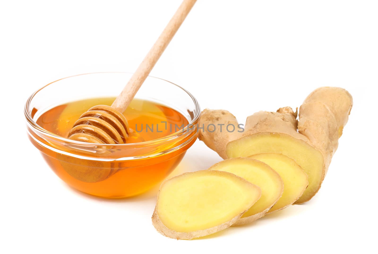 Honey in bowl and a slices ginger root on a white background