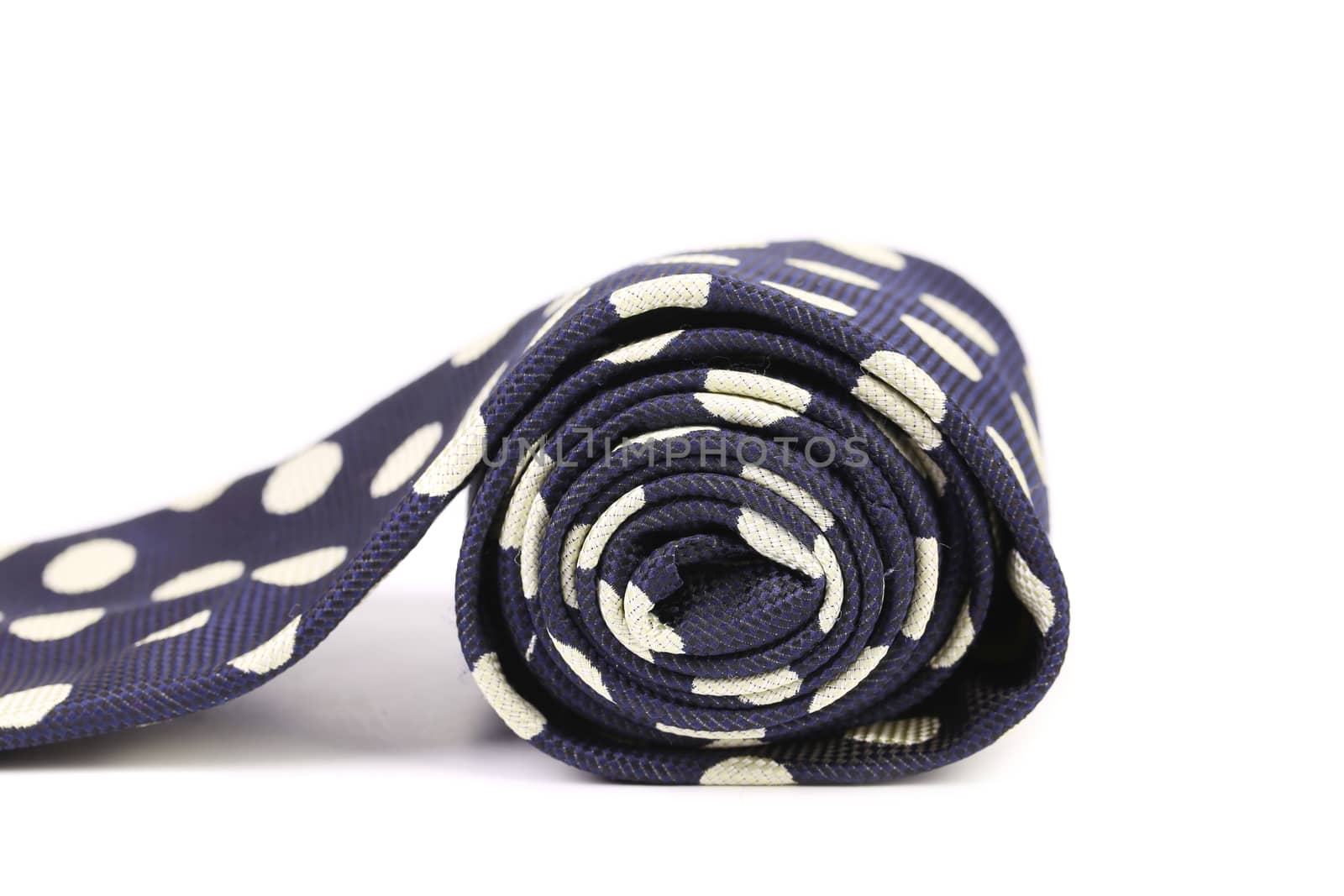 Rolled up polka dot necktie. Close up. White background.
