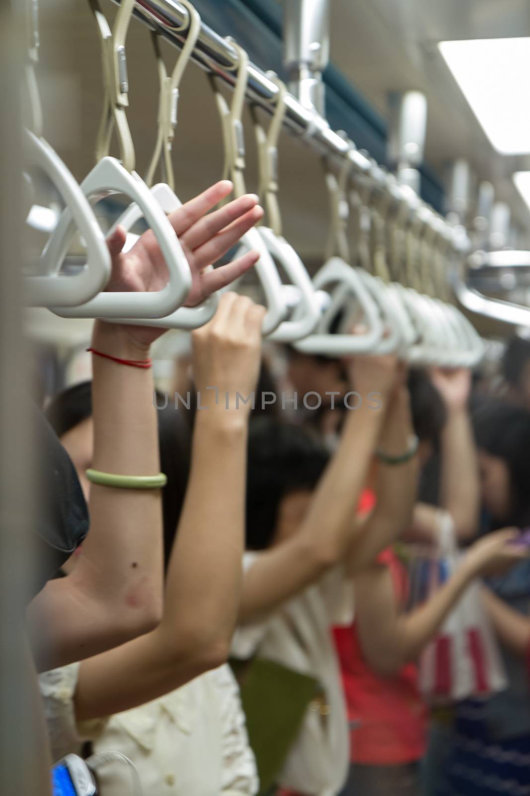 Hands on hand grips in subway coach