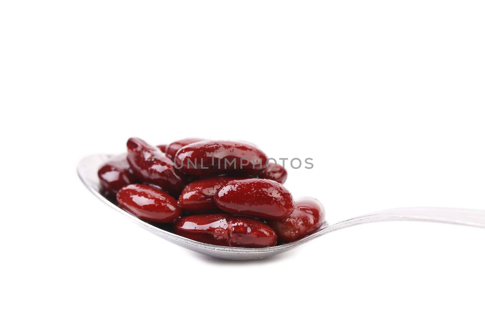 Kidney bean in metal spoon, isolated on white background