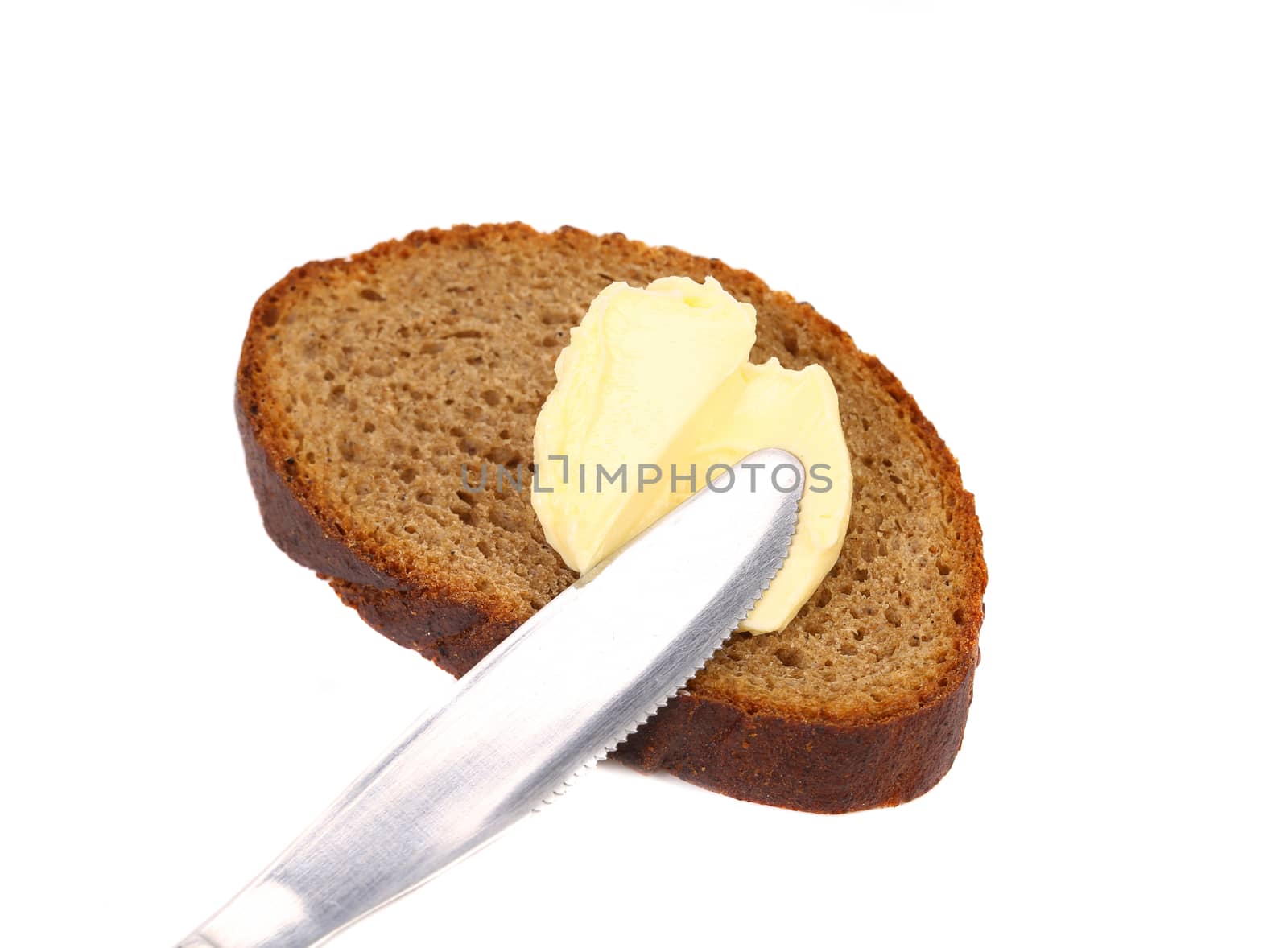 Buttering knife on brown bread. White background.