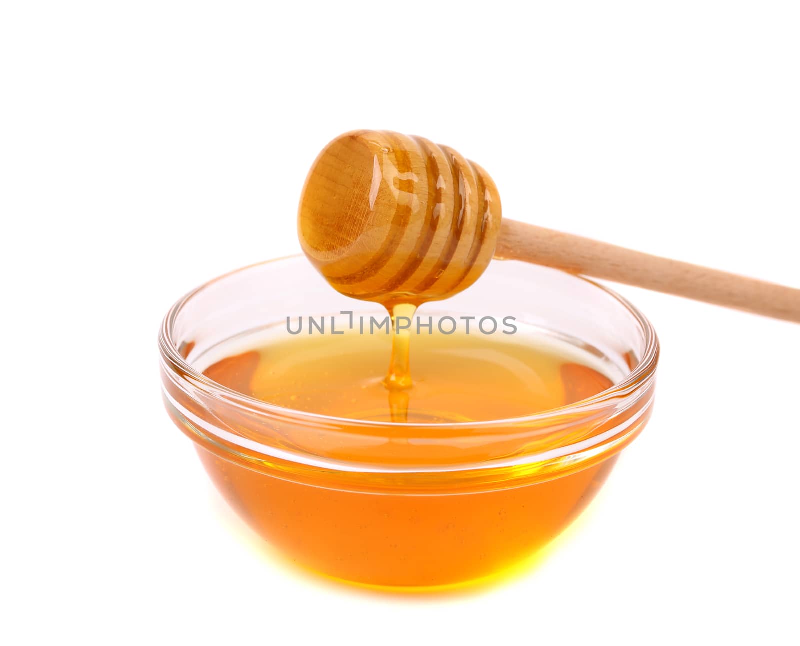 Bow of honey and wooden spoon. White background.