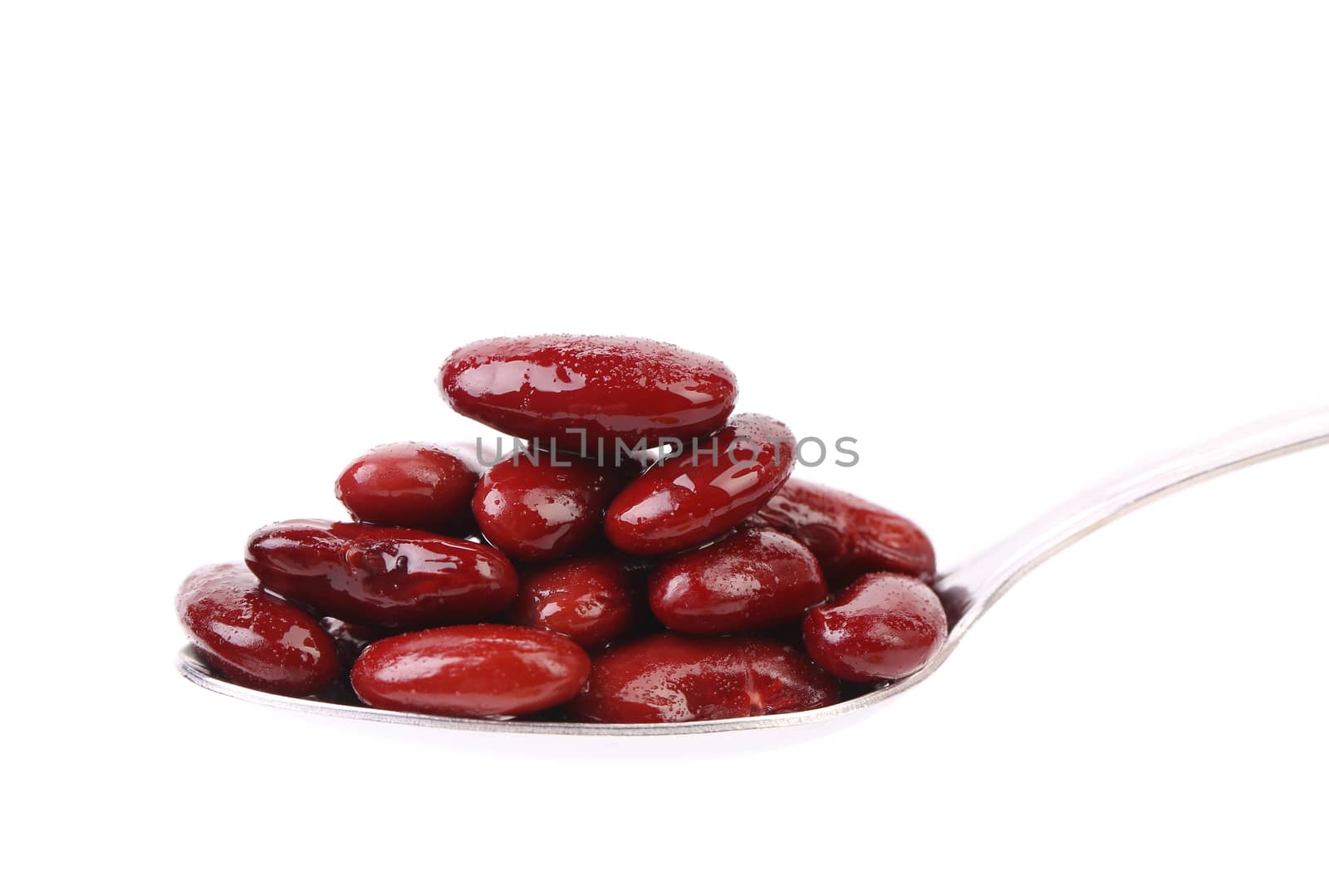 Preserve beans on a spoon. White background.