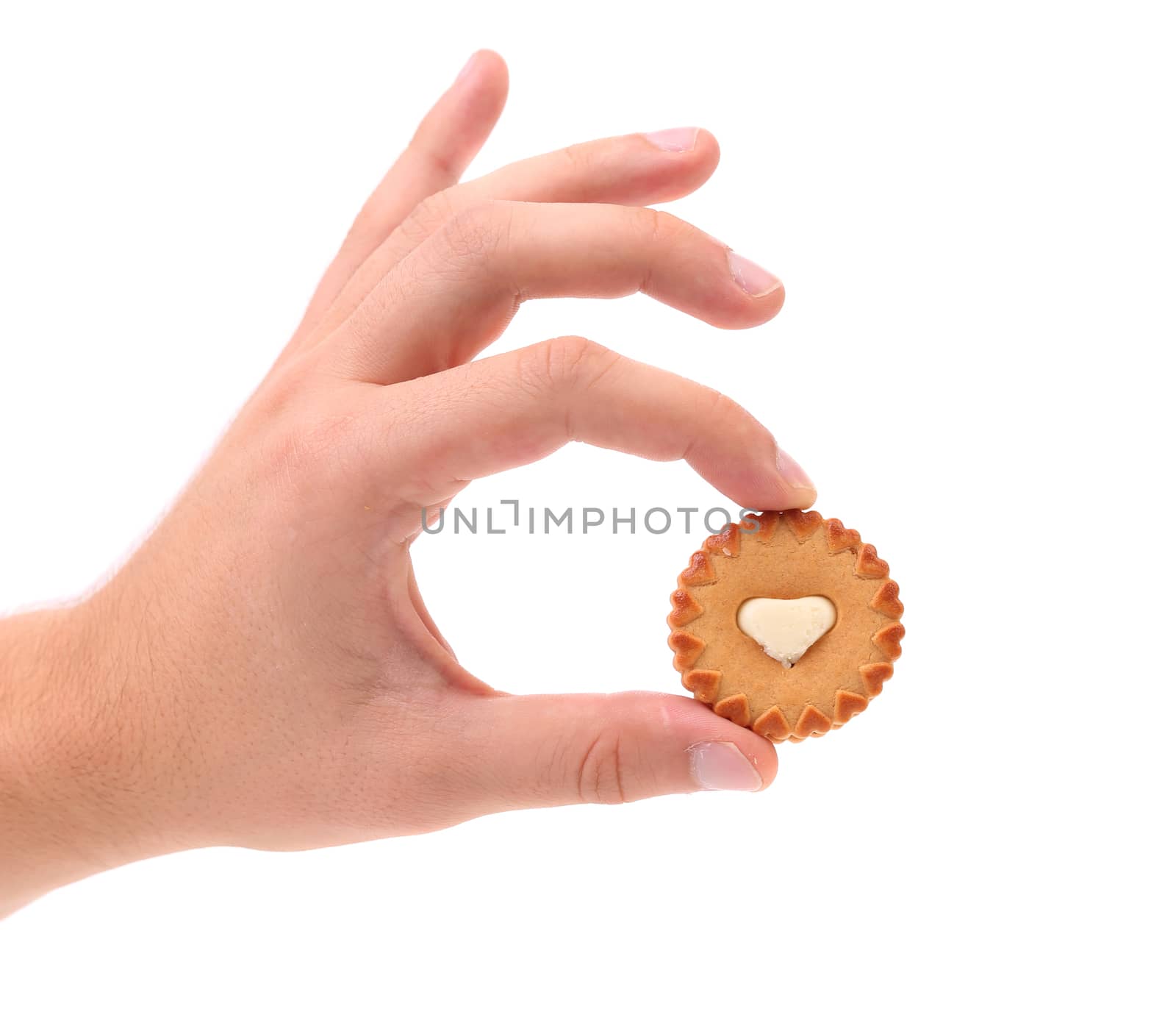 Hand holds sweet pastry with white cream heart. White background.